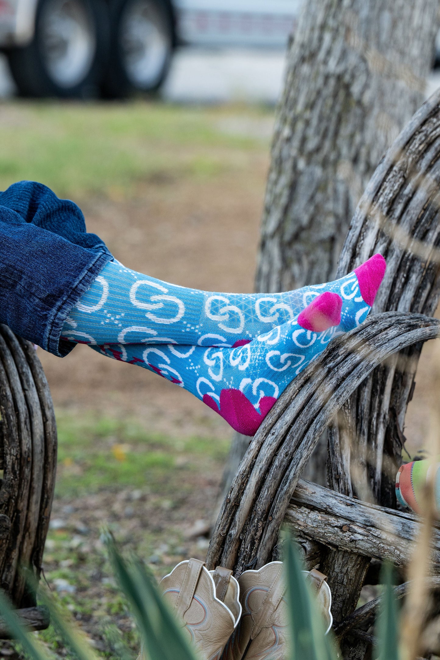 Person wearing blue patterned socks on wooden chair