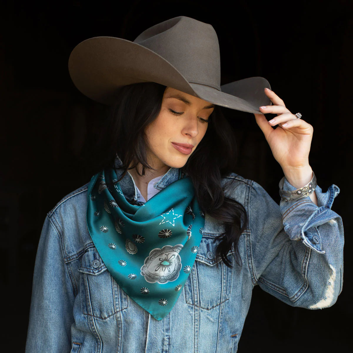 Woman wearing silk wild rag scarf and cowboy hat.