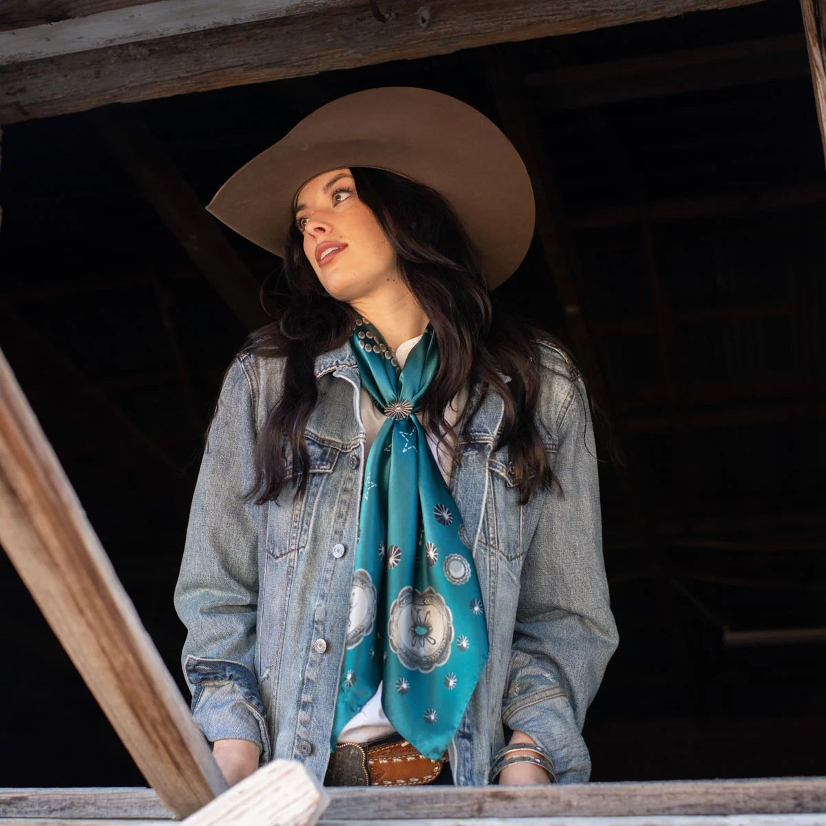 Woman in cowboy hat and silk scarf.