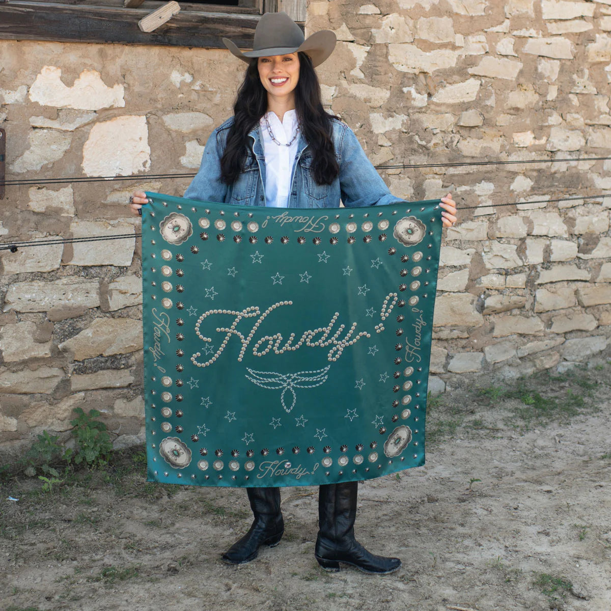 Woman holding a jade silk Howdy wild rag scarf with concho.