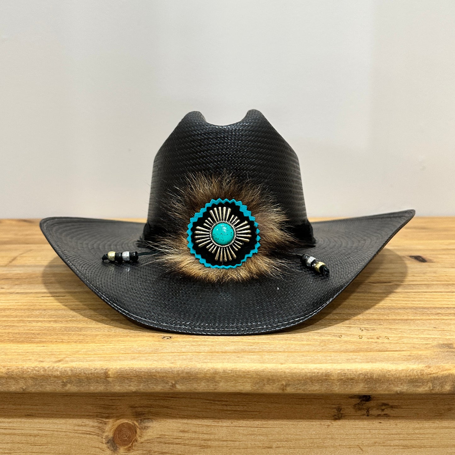 Black cowboy hat with turquoise and fur embellishment.