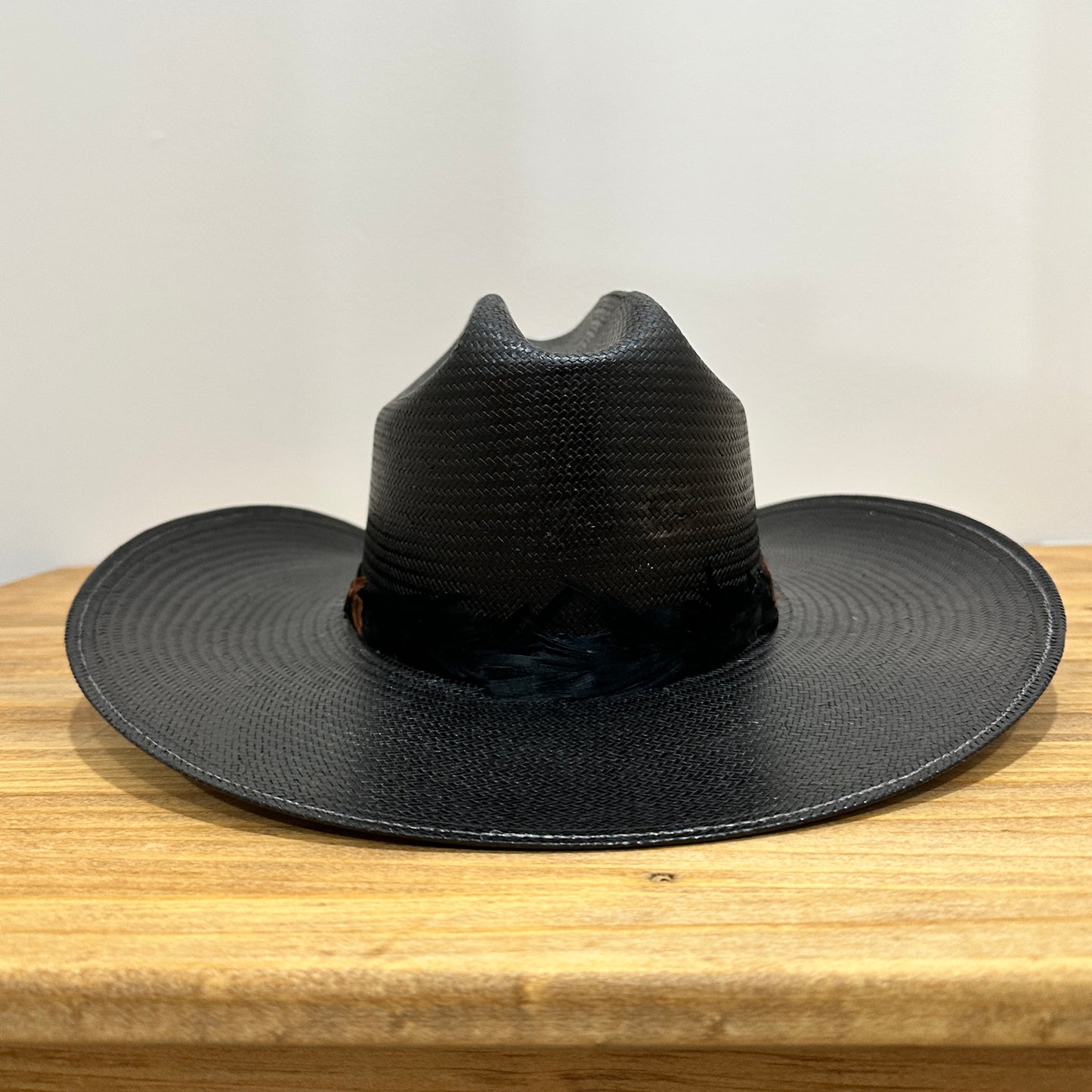 Black cowboy hat on a wooden surface.