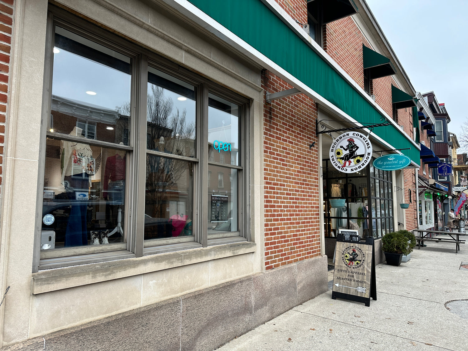 Storefront with green awning and shop sign.