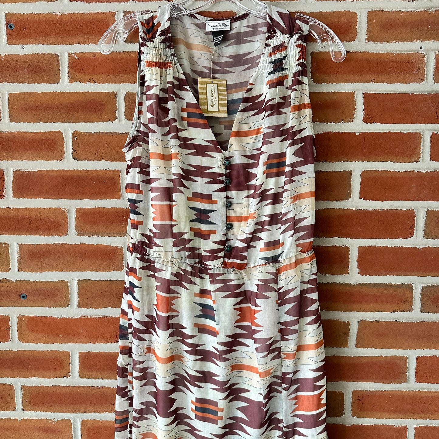 Patterned sleeveless dress hanging on a hanger.