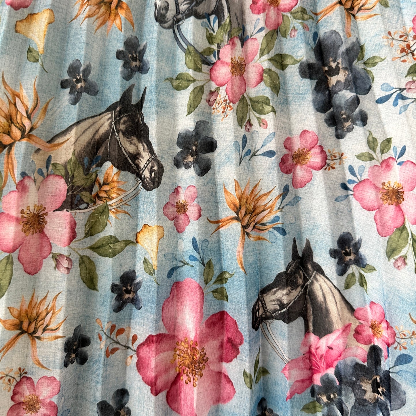 Fabric with horses and floral pattern.