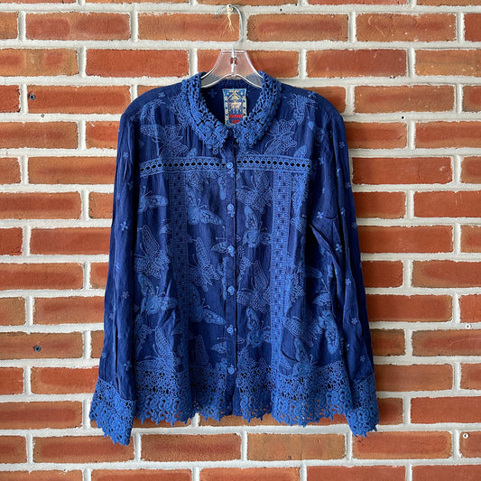Blue embroidered button-up shirt hanging on a hanger.
