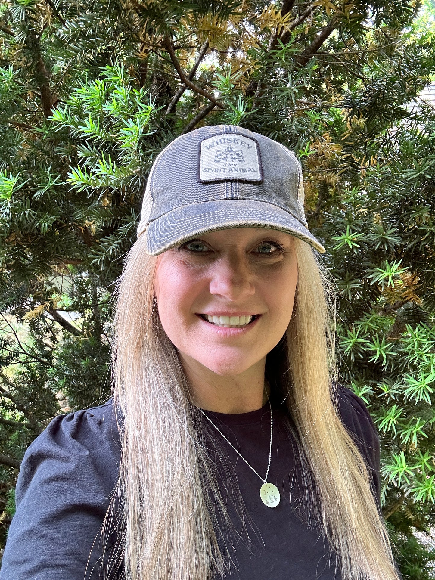 Woman wearing a hat and smiling.