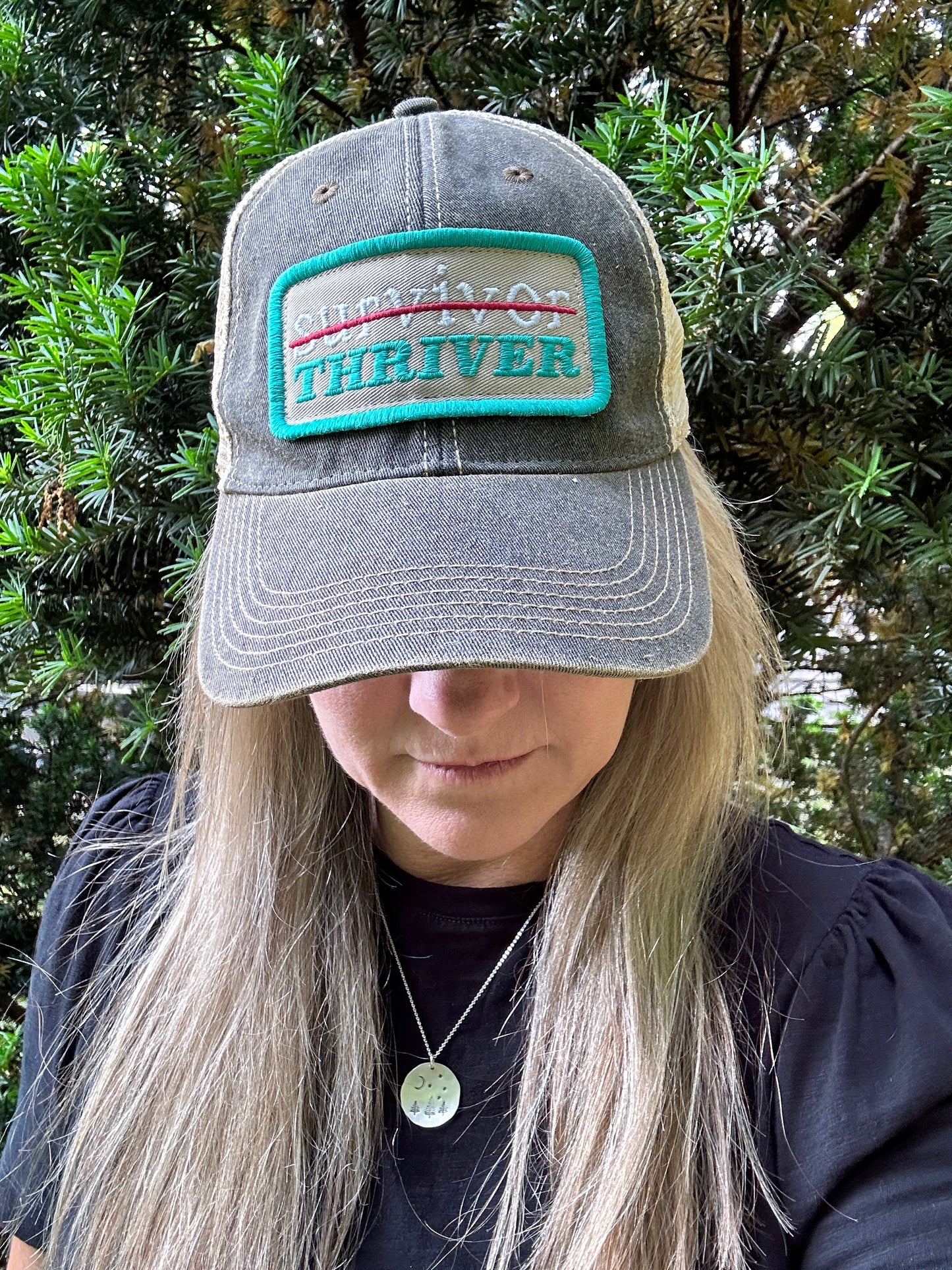 Woman wearing a hat that says THRIVER.