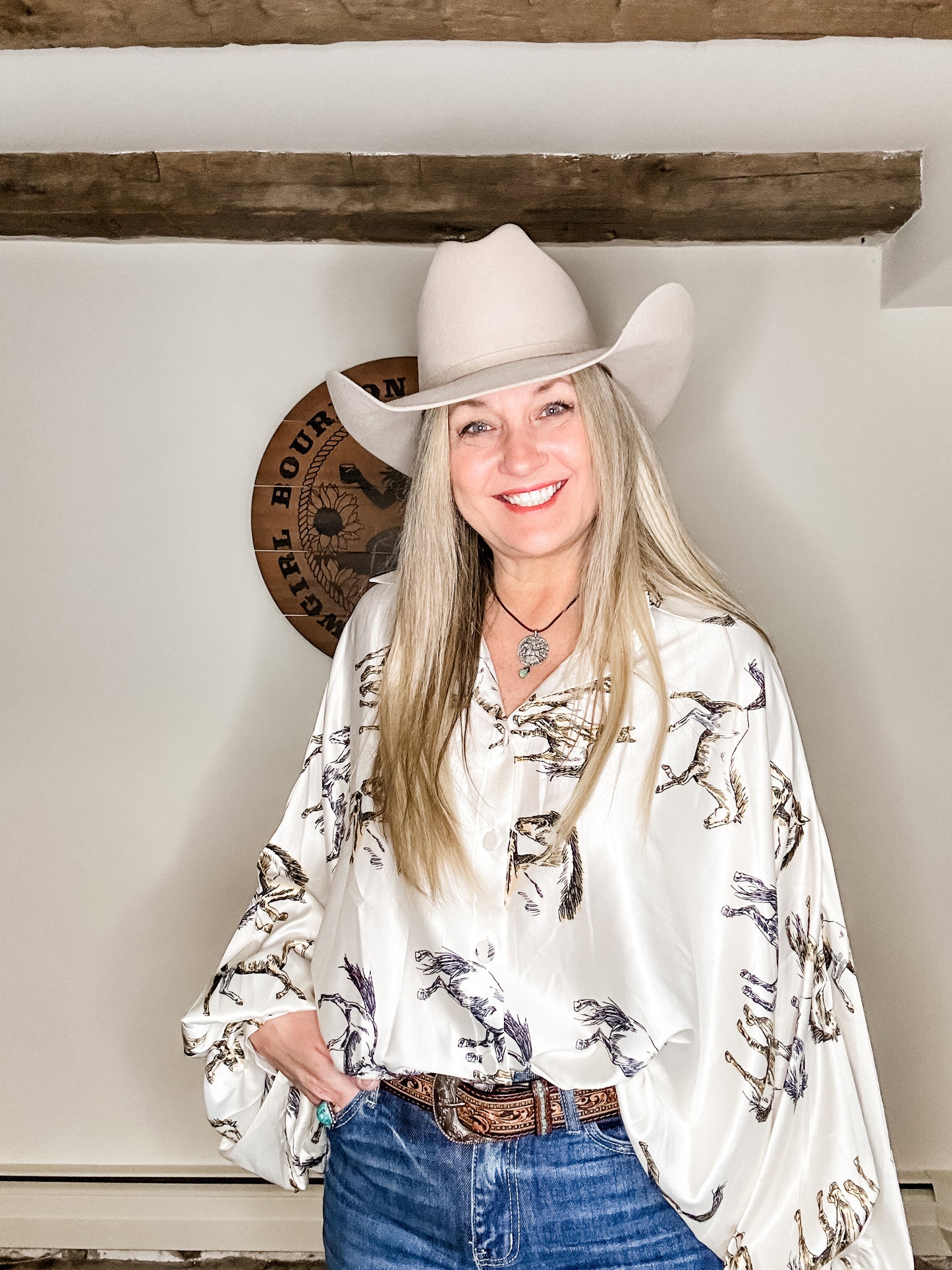 Woman in cowboy hat and patterned blouse.