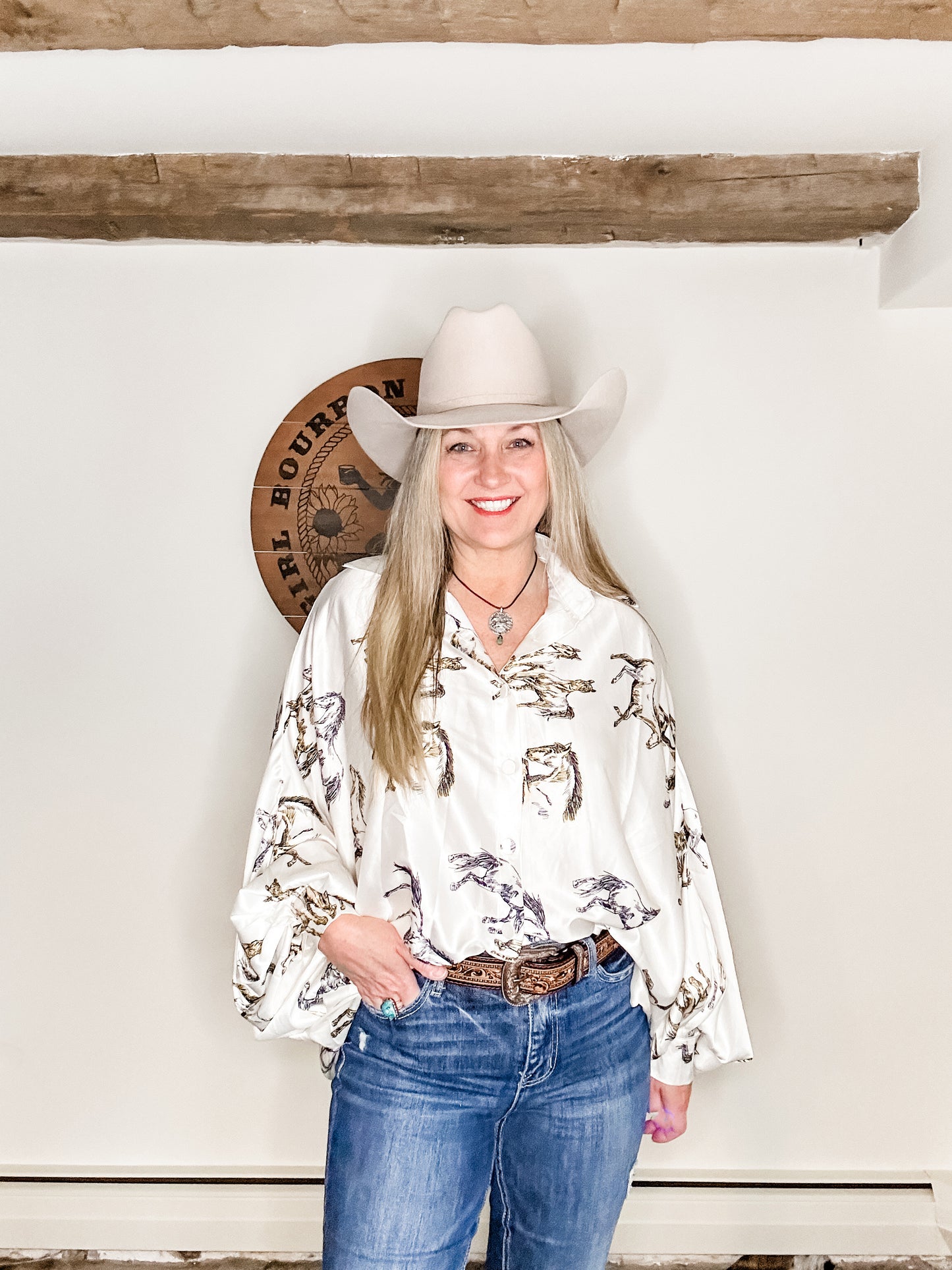 Woman in cowboy hat and patterned shirt.