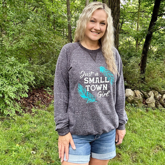 Woman in sweatshirt and shorts outdoors.