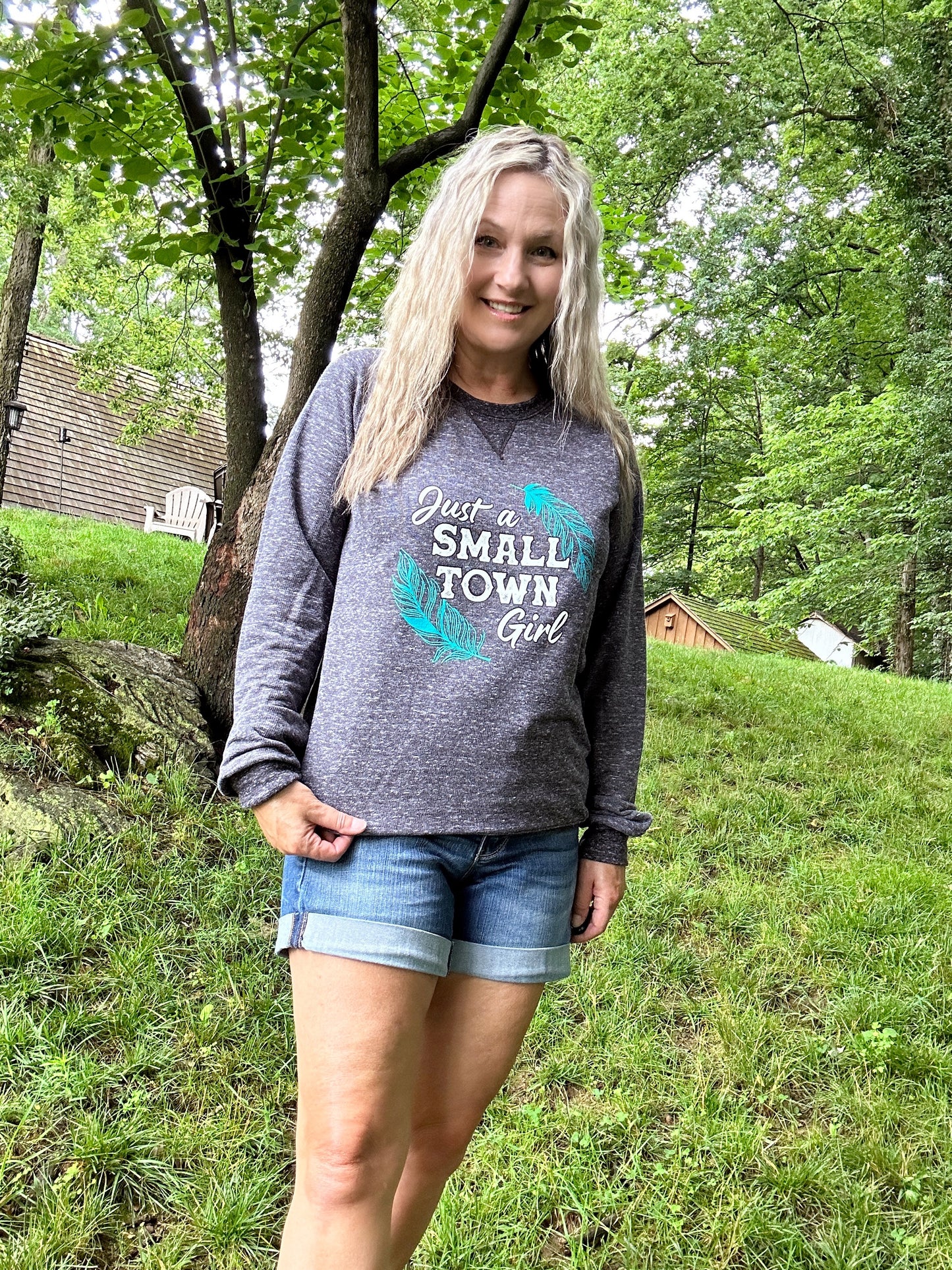 Woman in sweatshirt and shorts outdoors.