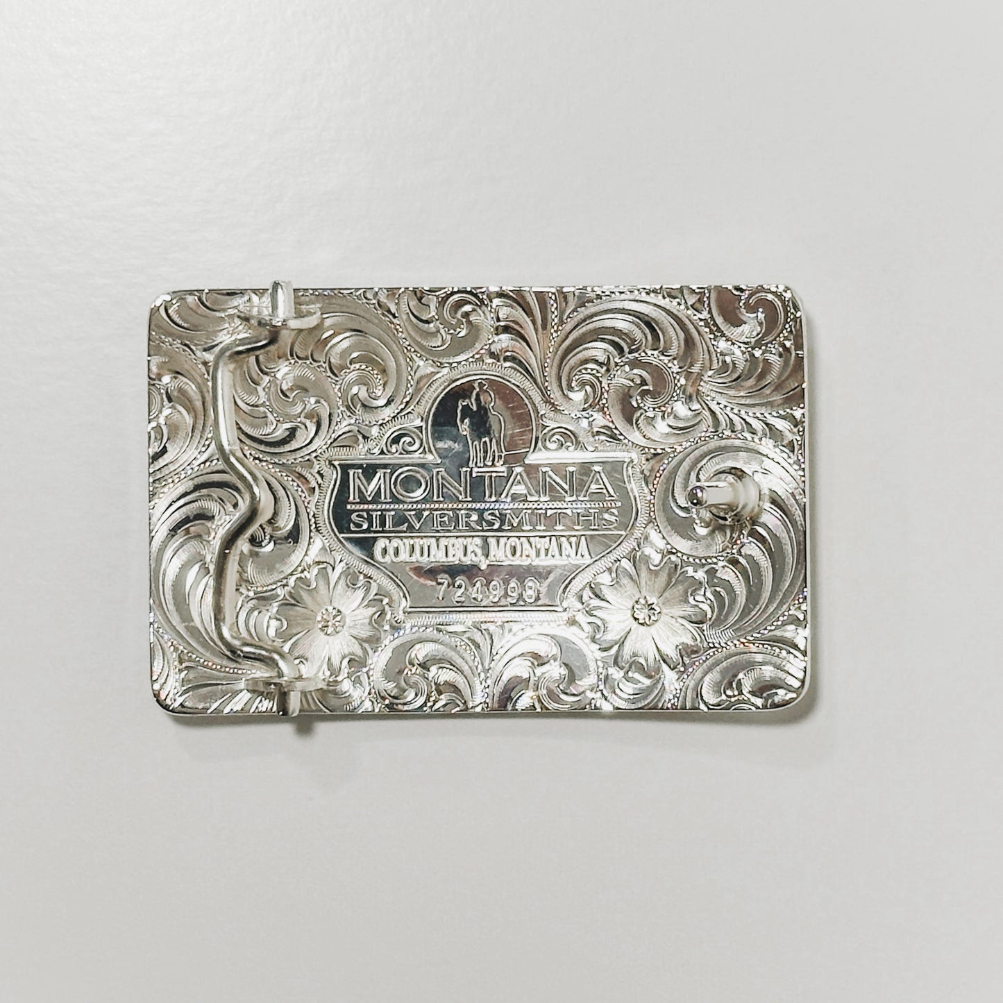 Silver belt buckle with engraved design.