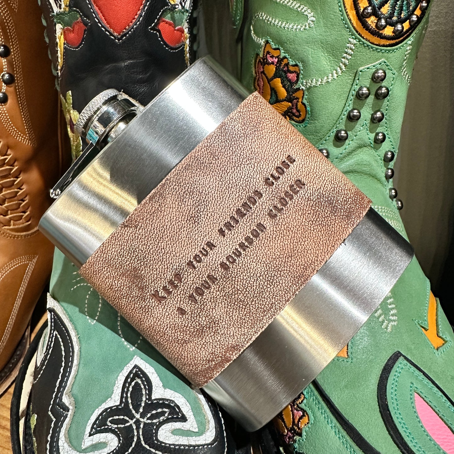 Flask with leather band and cowboy boots.