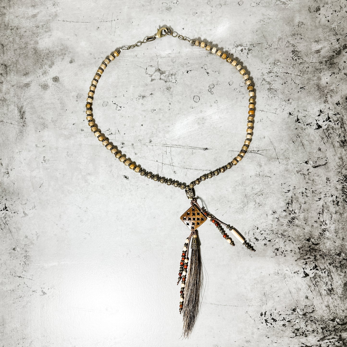 Beaded necklace with pendant and tassel.