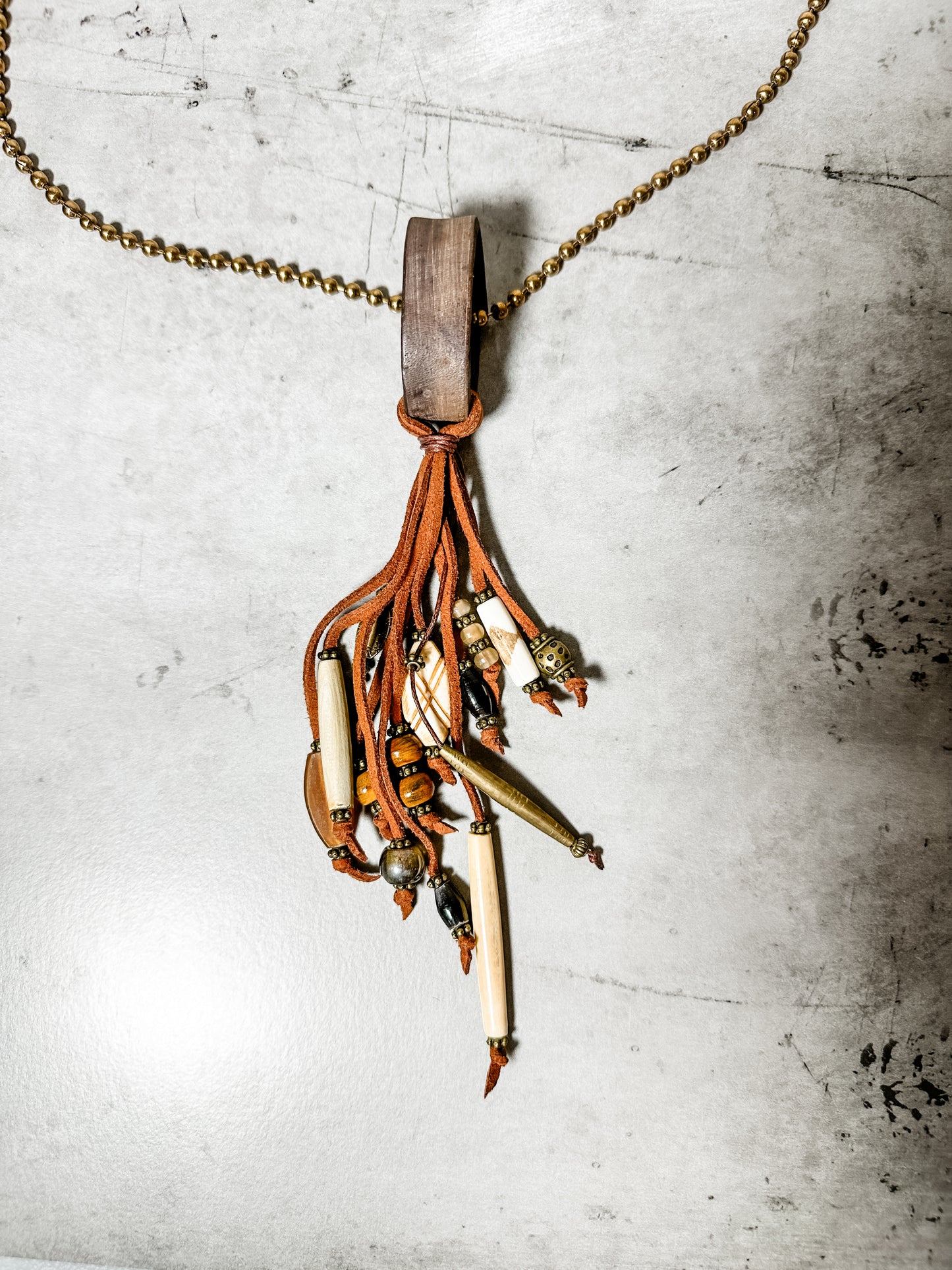 Necklace with leather, beads, and wooden pendant.