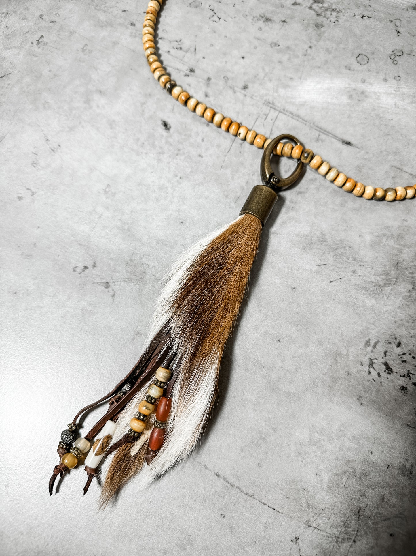 Necklace with fur and bead pendant.