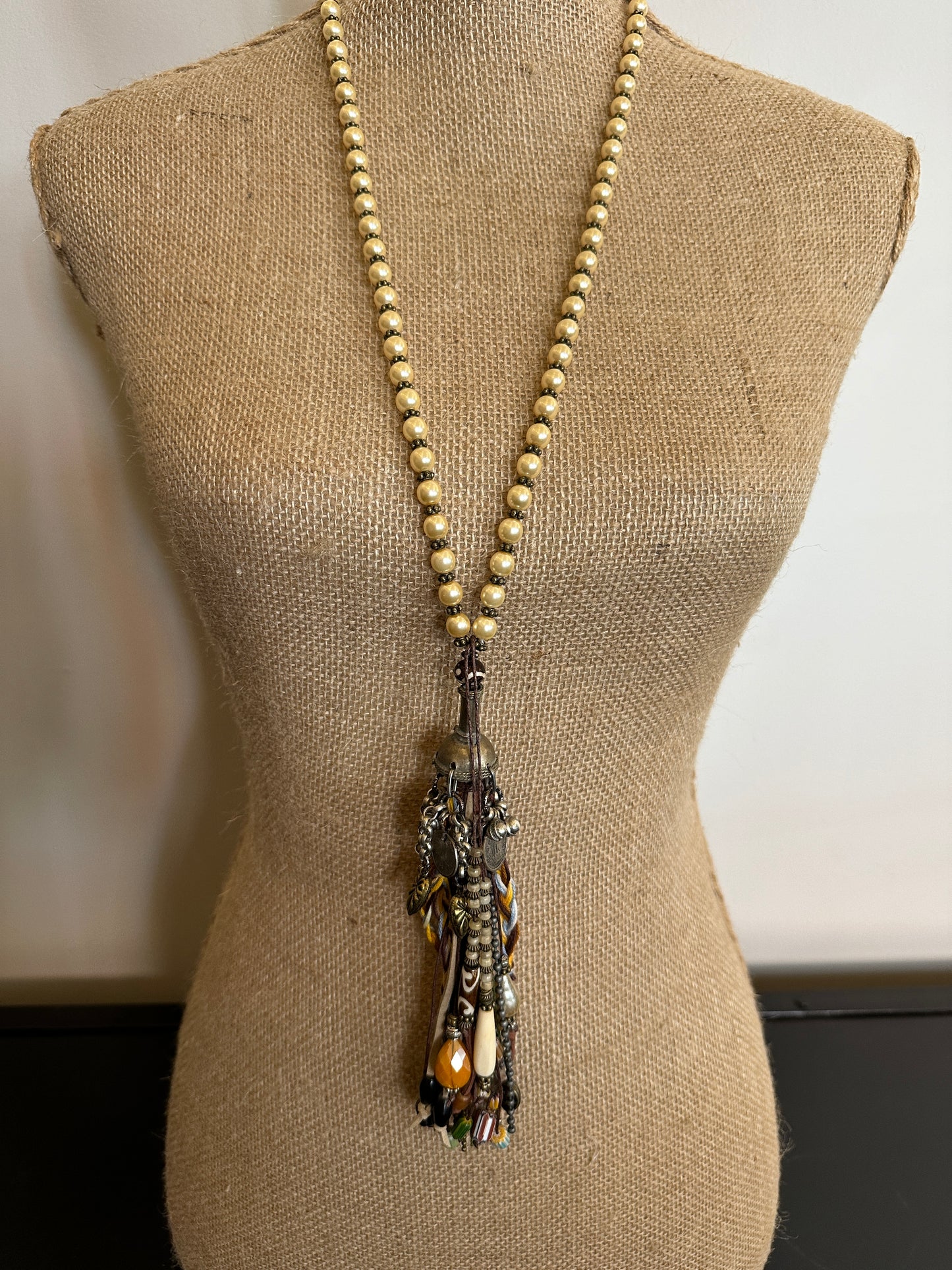 Beaded necklace with tassel on mannequin.