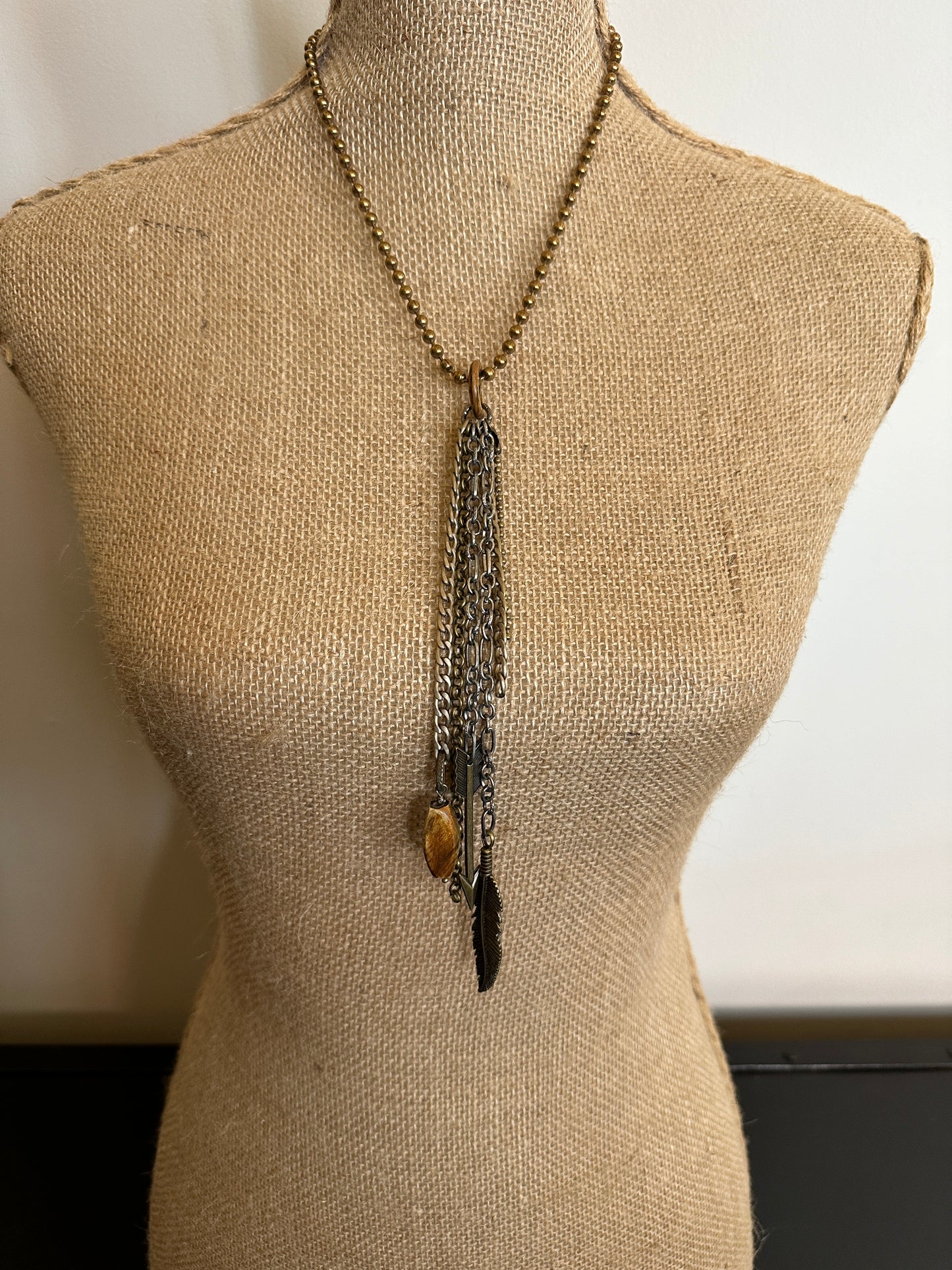 Necklace with charms on a mannequin.