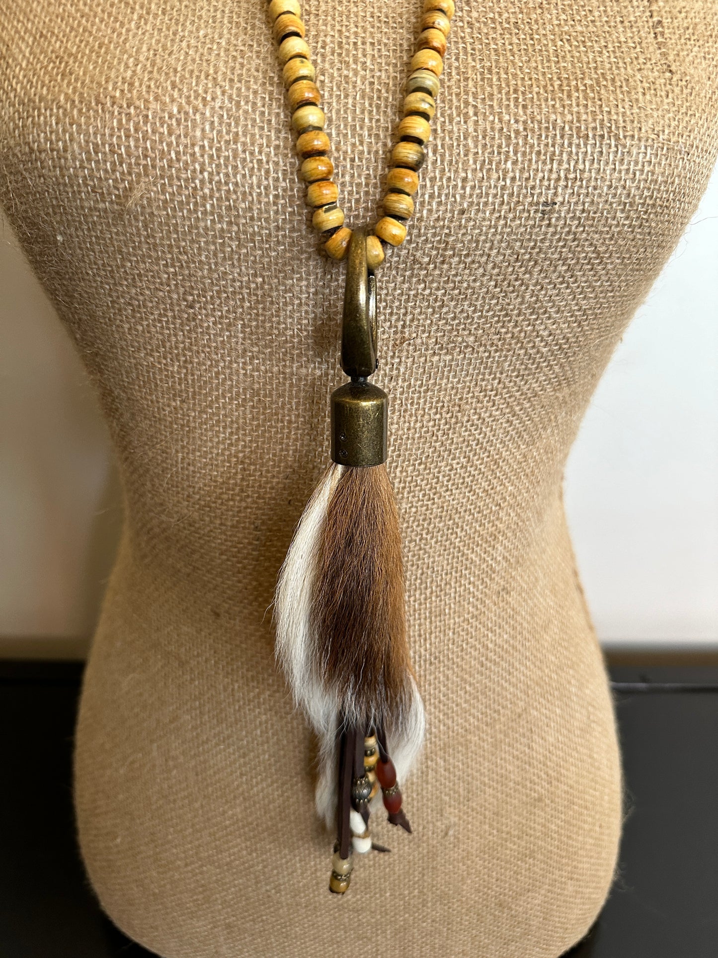 Necklace with fur tassel on a mannequin.