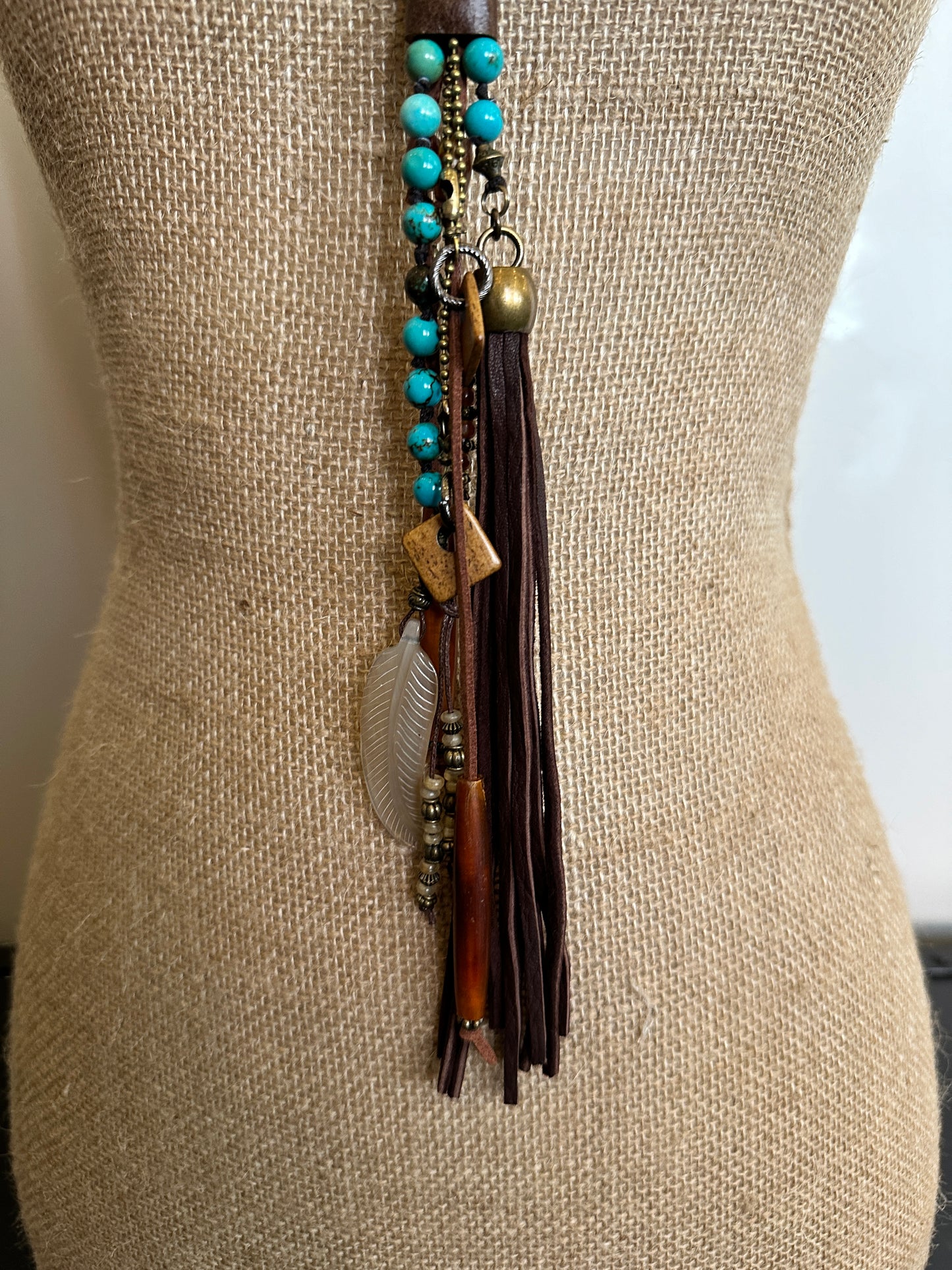 Necklace with turquoise beads and leather tassel.