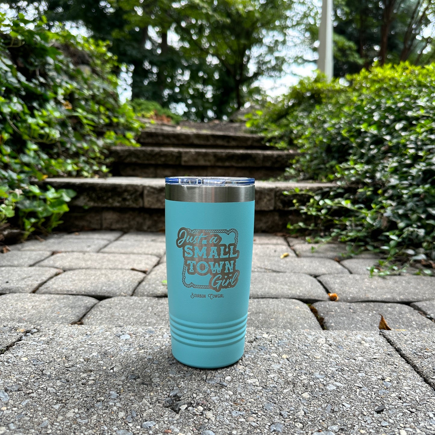 Blue Small Town Girl tumbler on stone path.