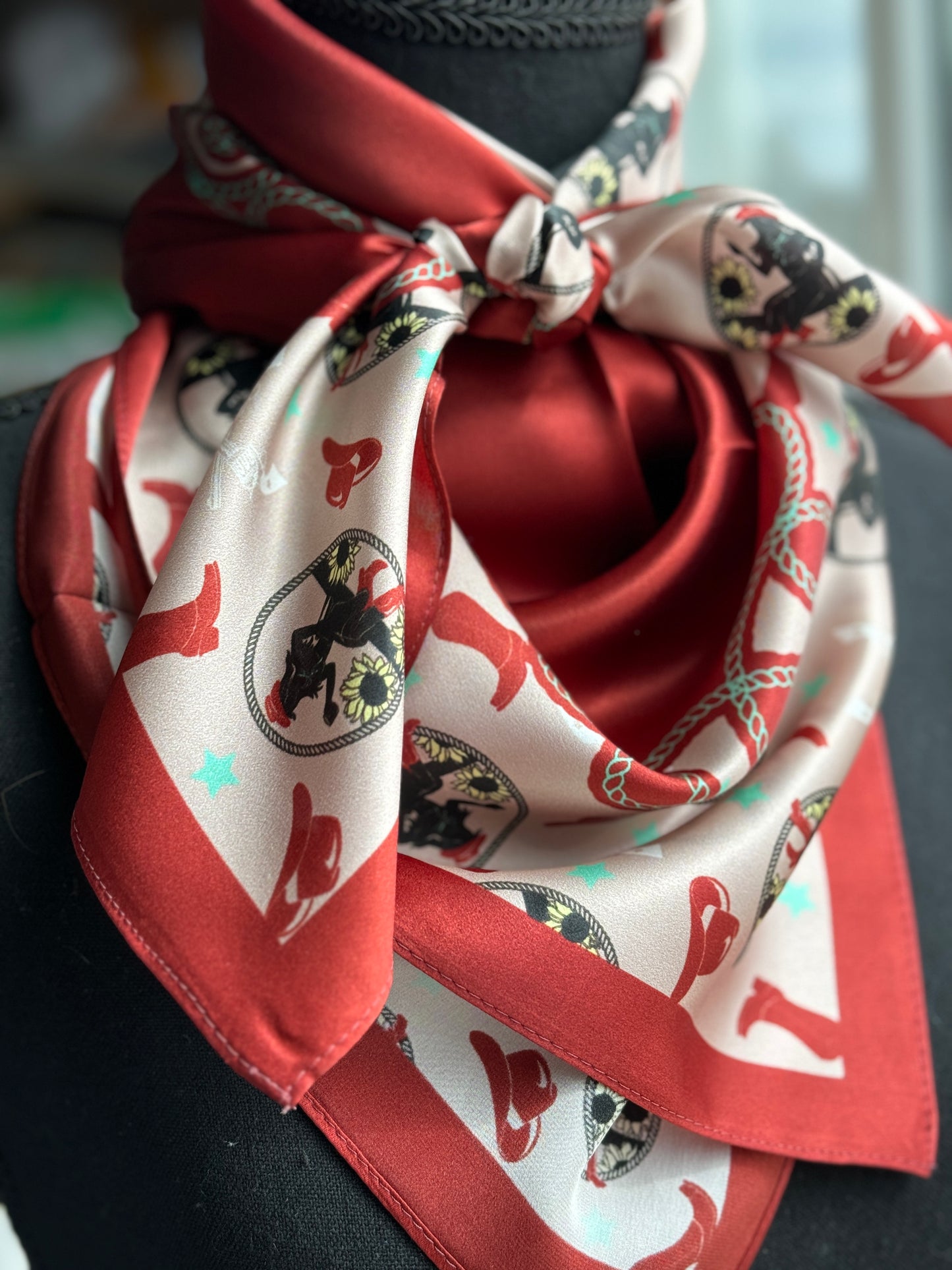 Red and white patterned cowboy scarf tied around a neck.