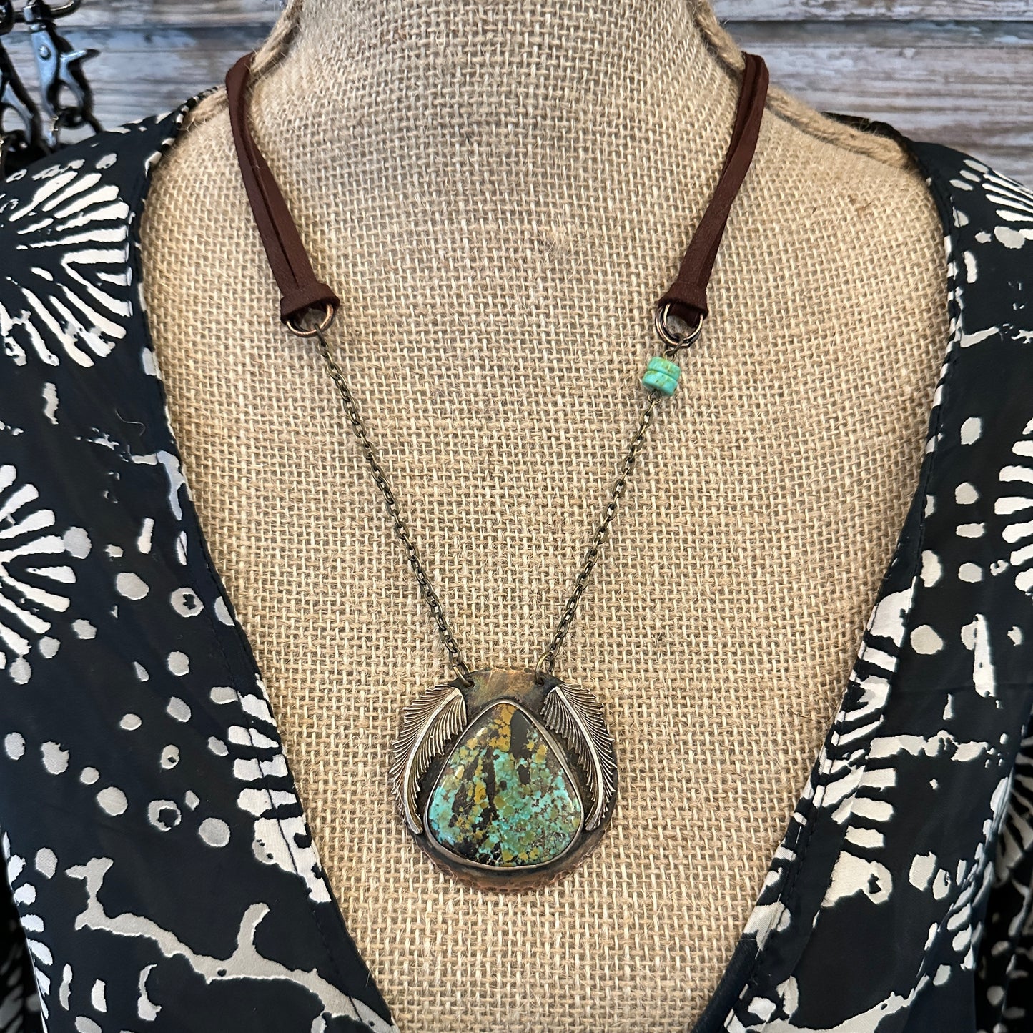 Necklace with turquoise pendant on mannequin.