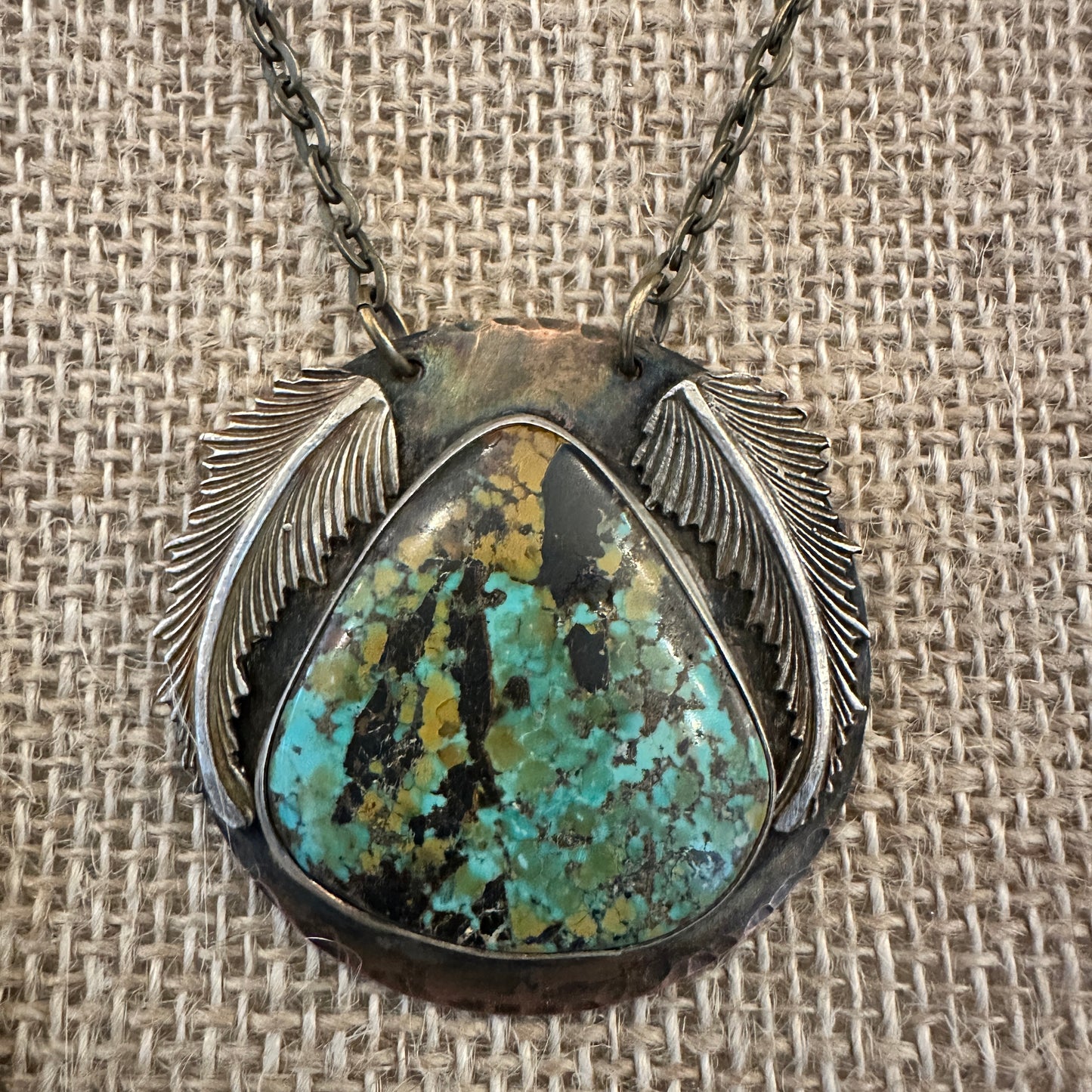 Turquoise pendant necklace with silver wings.