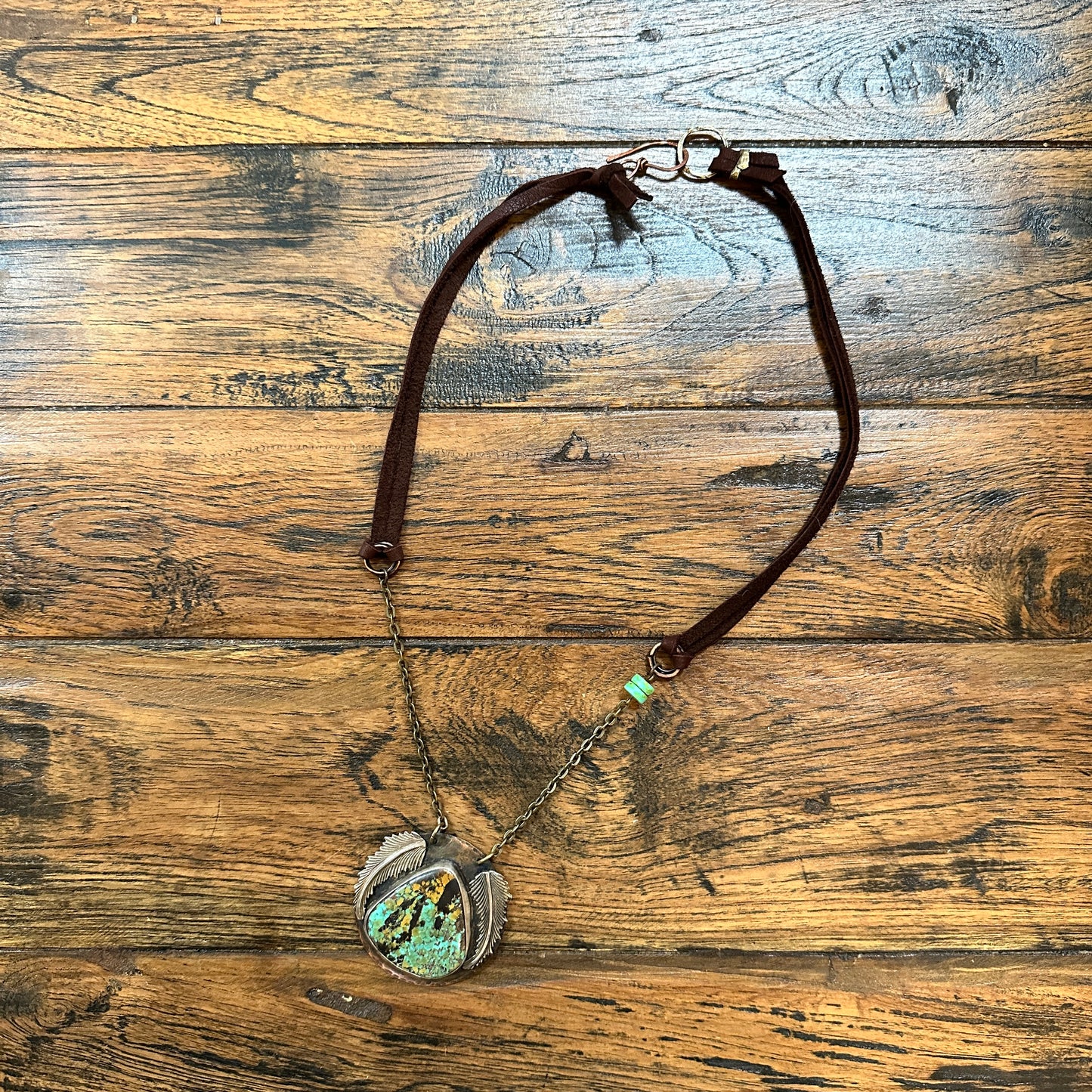 Necklace with pendant on a wooden surface.