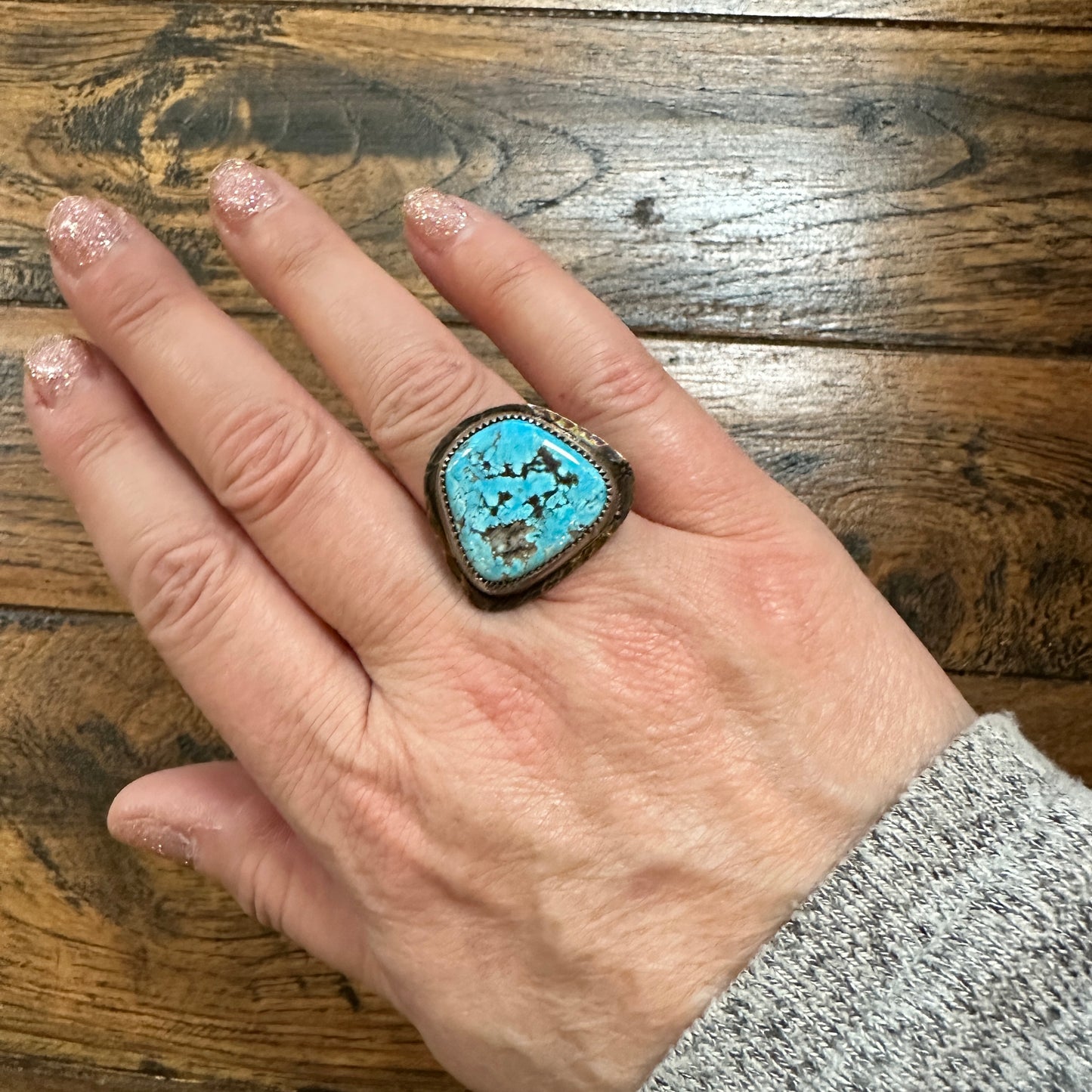 Hand wearing turquoise ring.