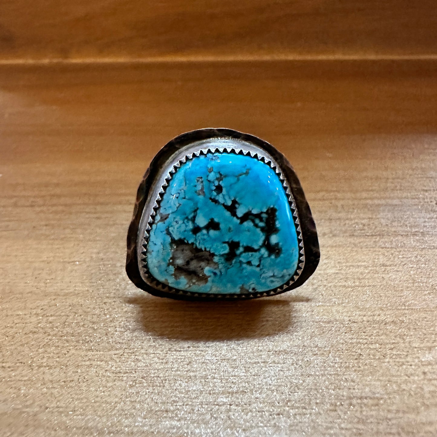 Turquoise ring on a wooden surface.