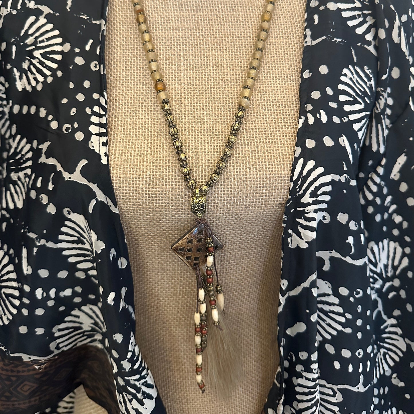 Beaded necklace on patterned fabric.