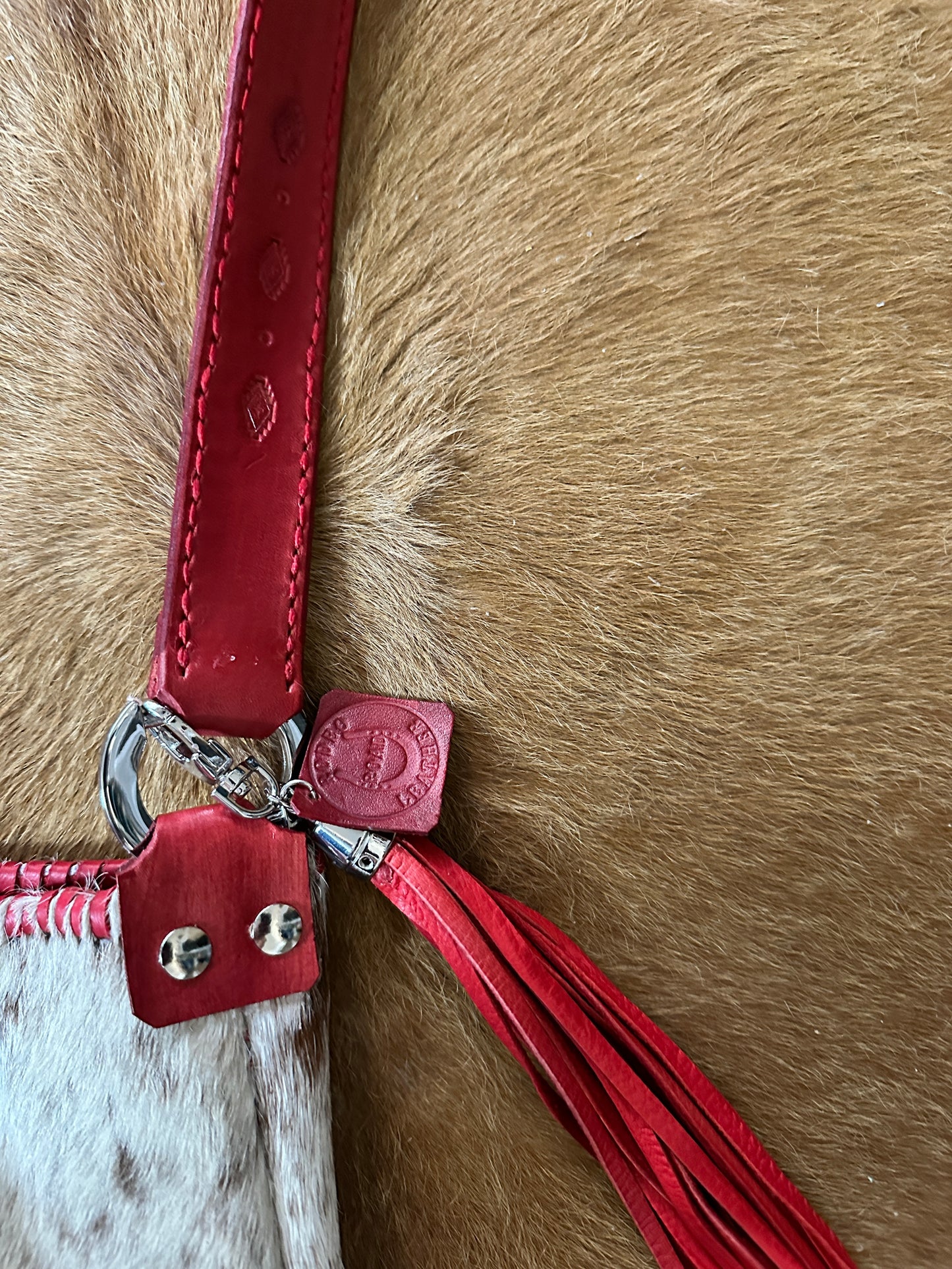 Red leather purse strap with tassel.