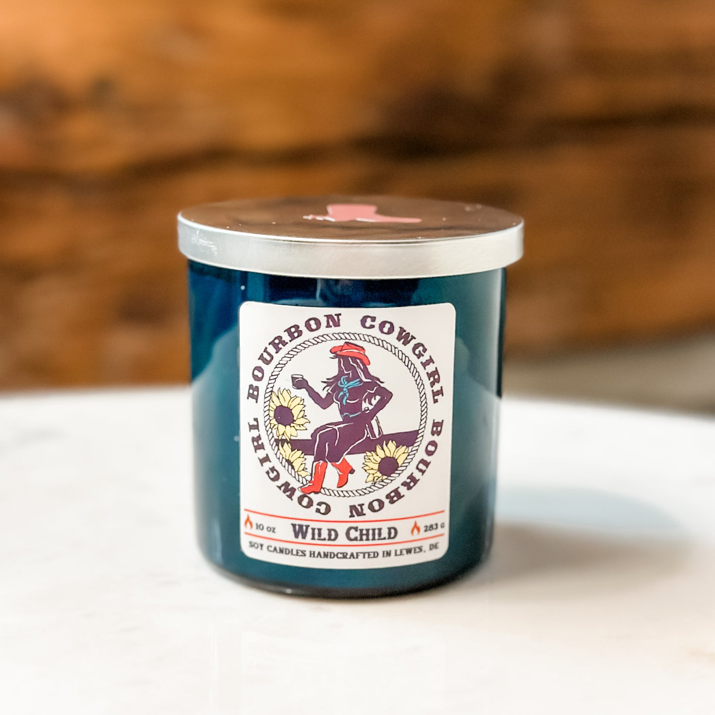 Blue candle with Bourbon Cowgirl label.