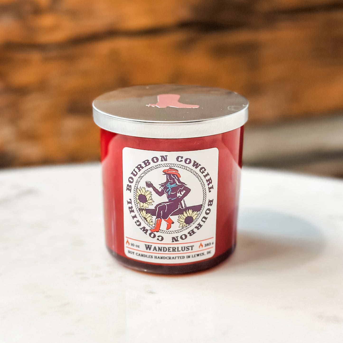 Red candle with silver lid and Bourbon Cowgirl label.