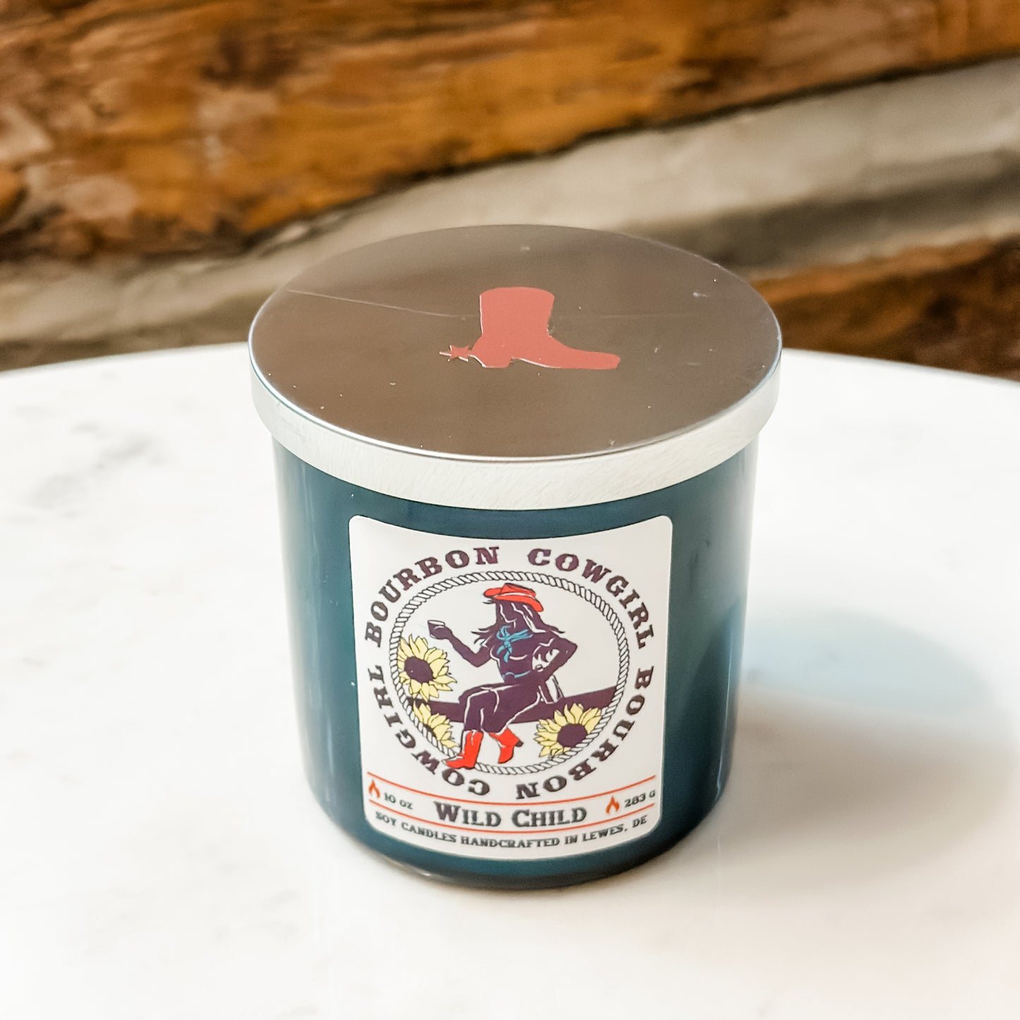 Blue candle with Bourbon Cowgirl label and boot lid.