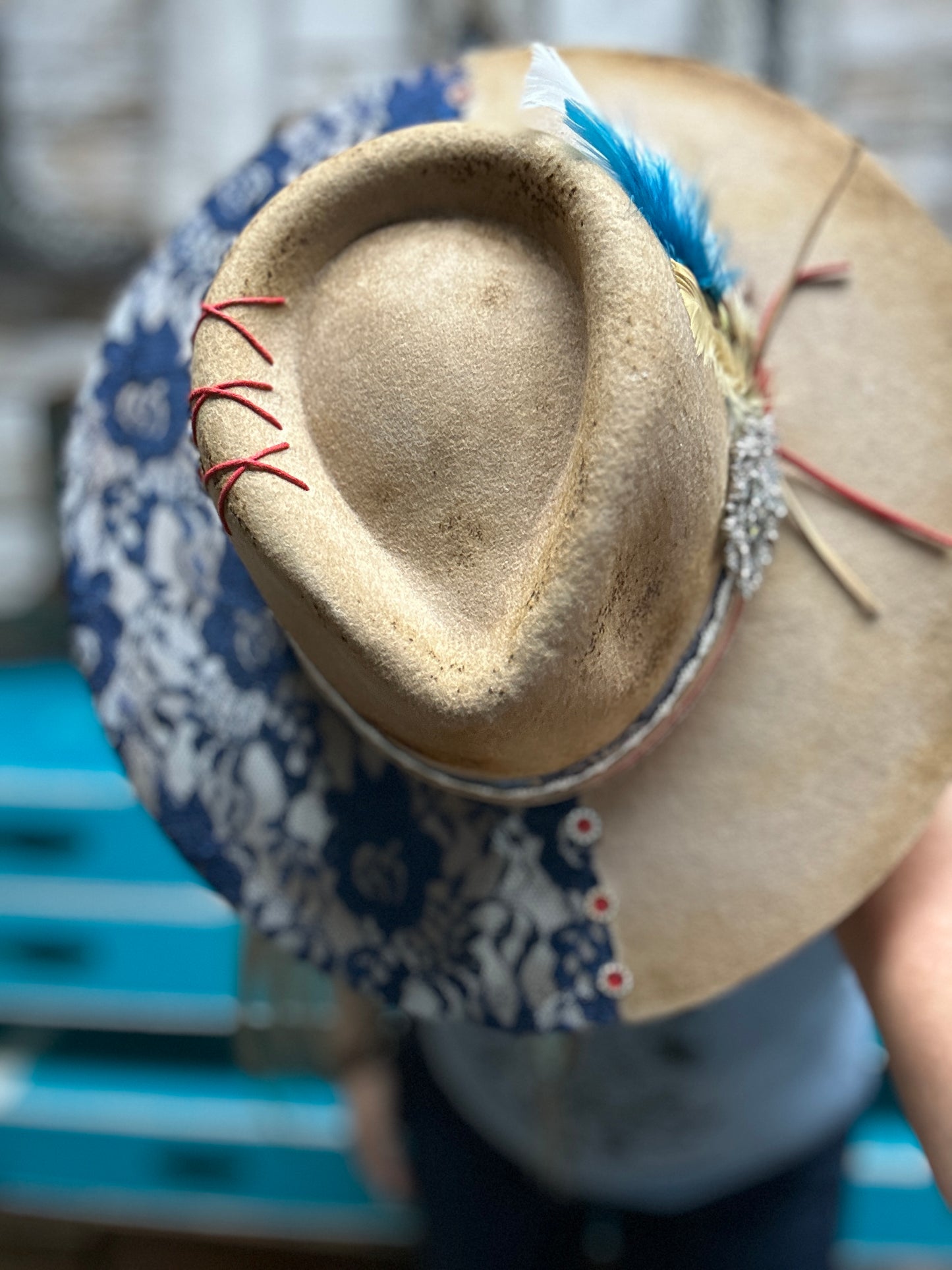 Tan and blue floral hat with feather.