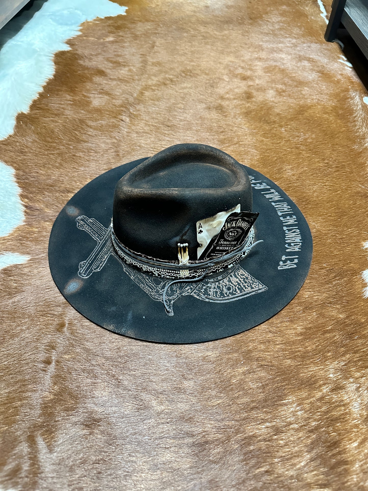Black hat with decorative brim on cowhide.