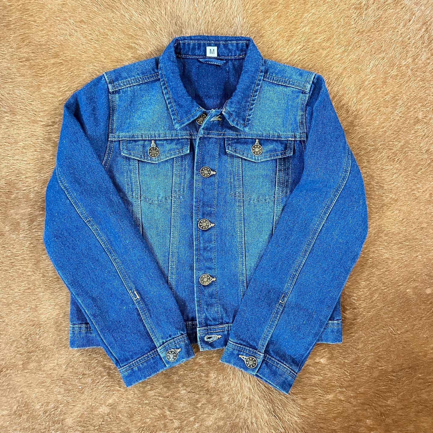Blue denim jacket on a brown surface.