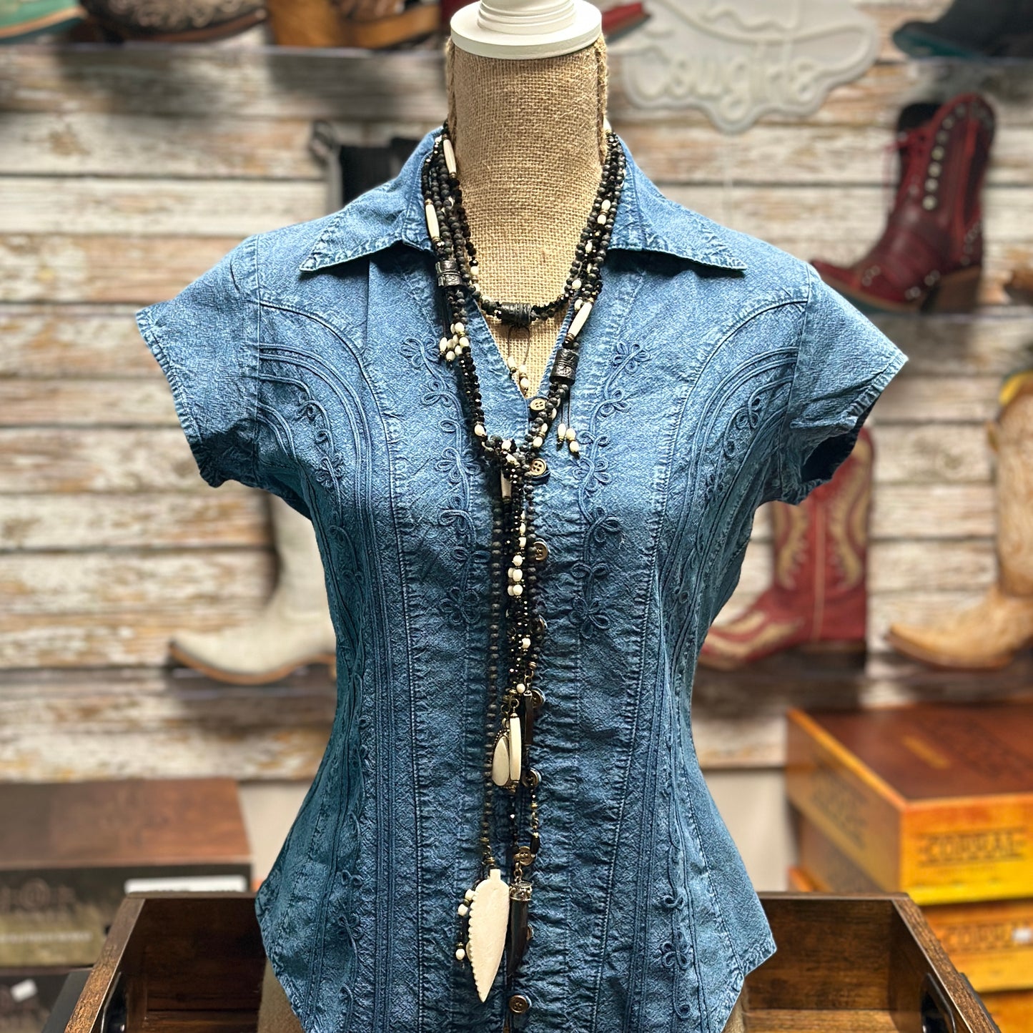 Blue denim shirt with necklace.