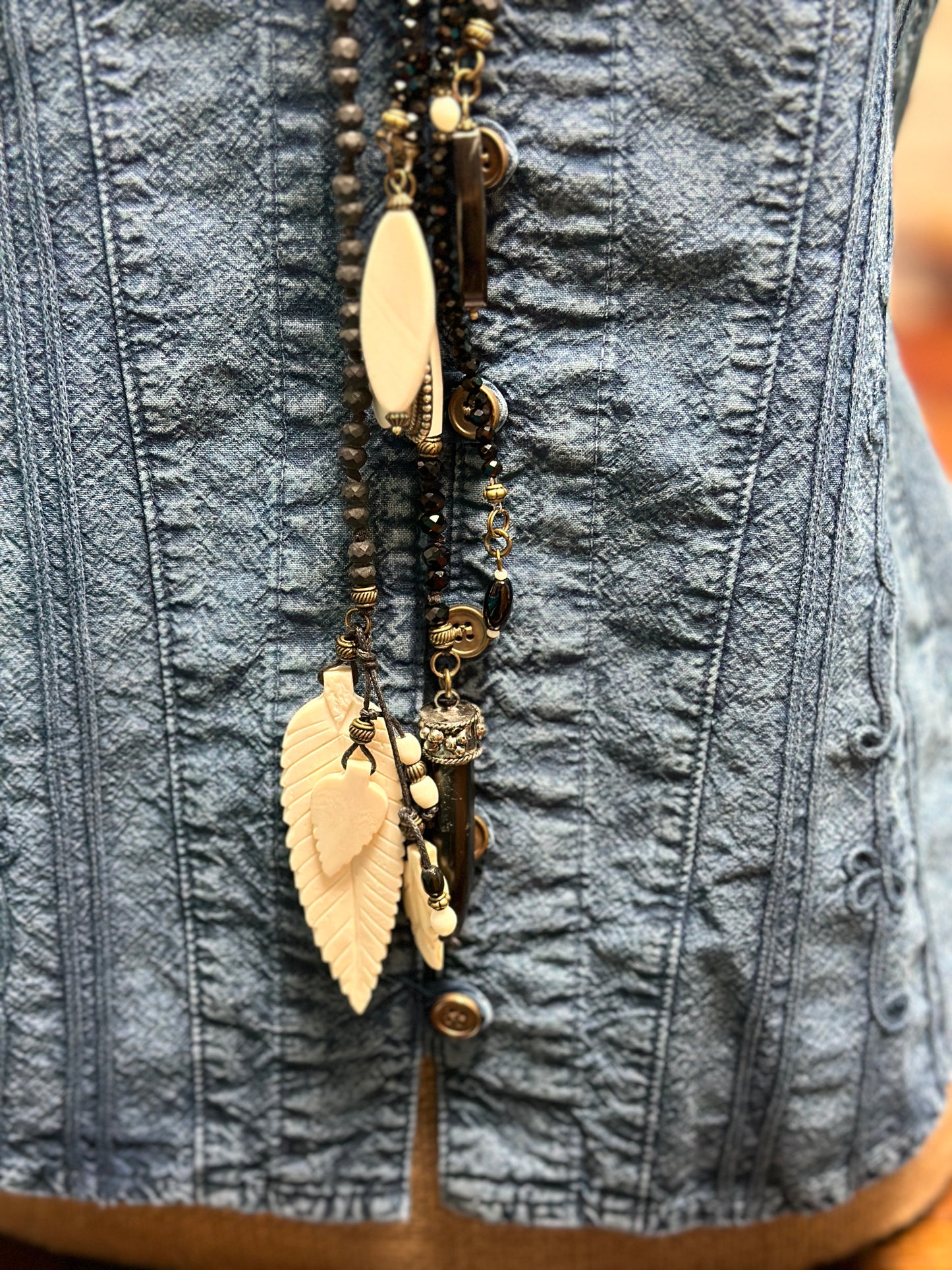 Denim corset with beaded necklace.