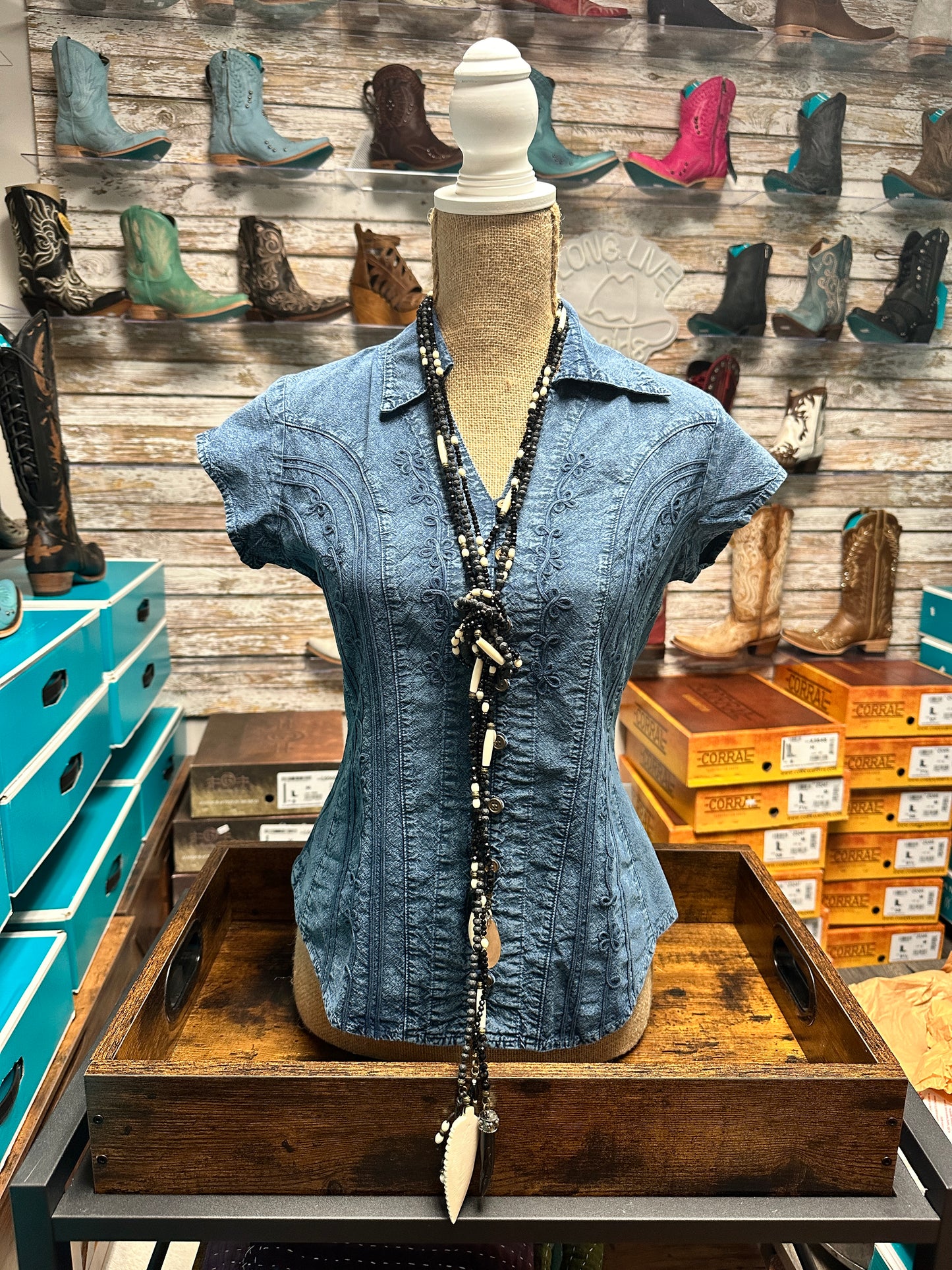 Blue shirt with necklace on display.