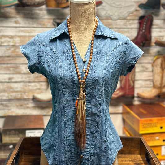 Blue embroidered shirt and necklace.