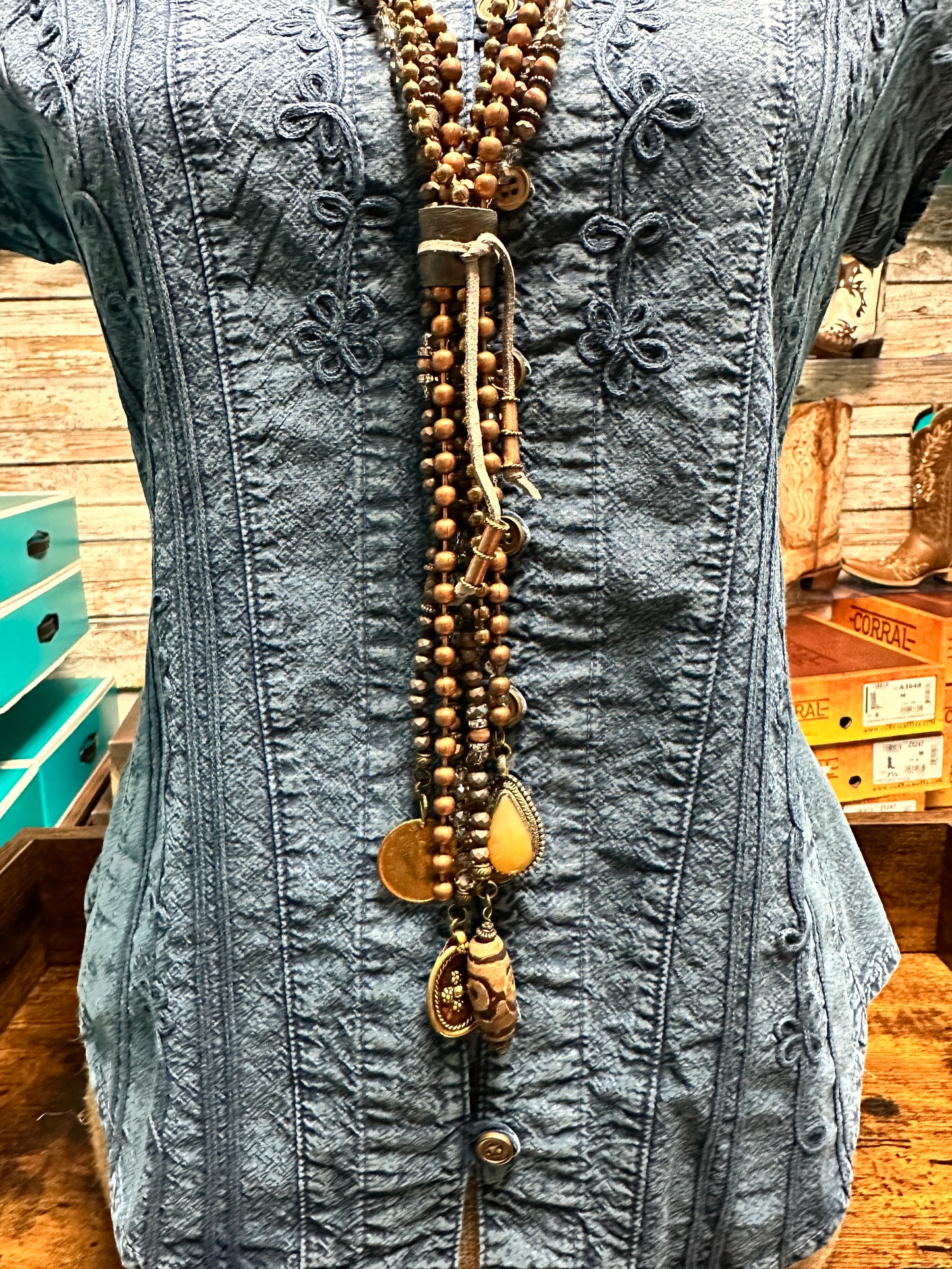 Blue denim top with beaded necklace.