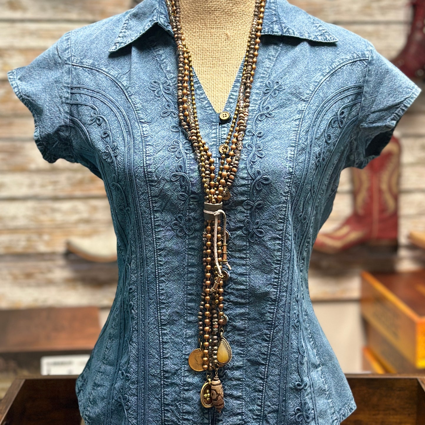 Blue denim shirt with beaded necklace.