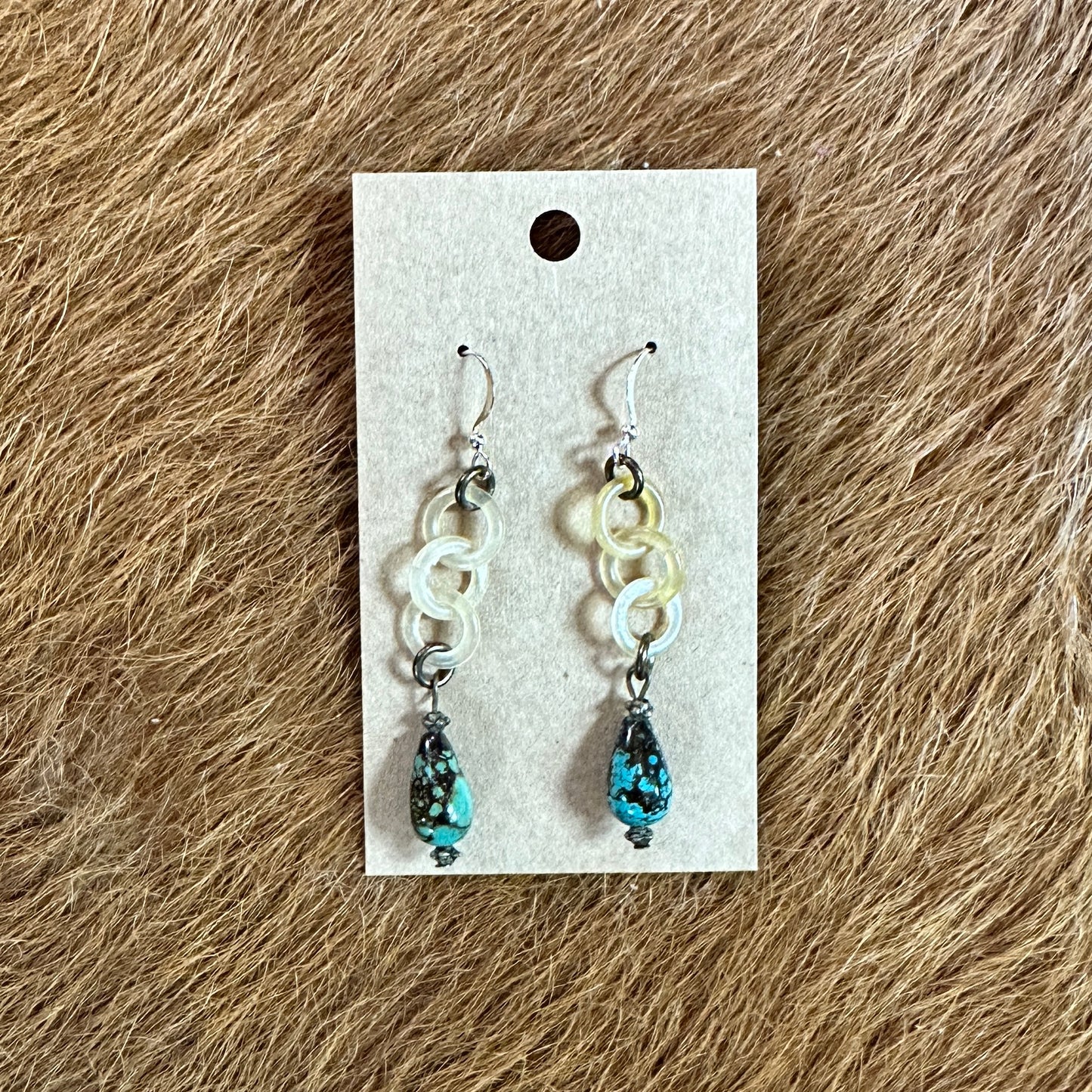 Earrings with turquoise beads on a display card.