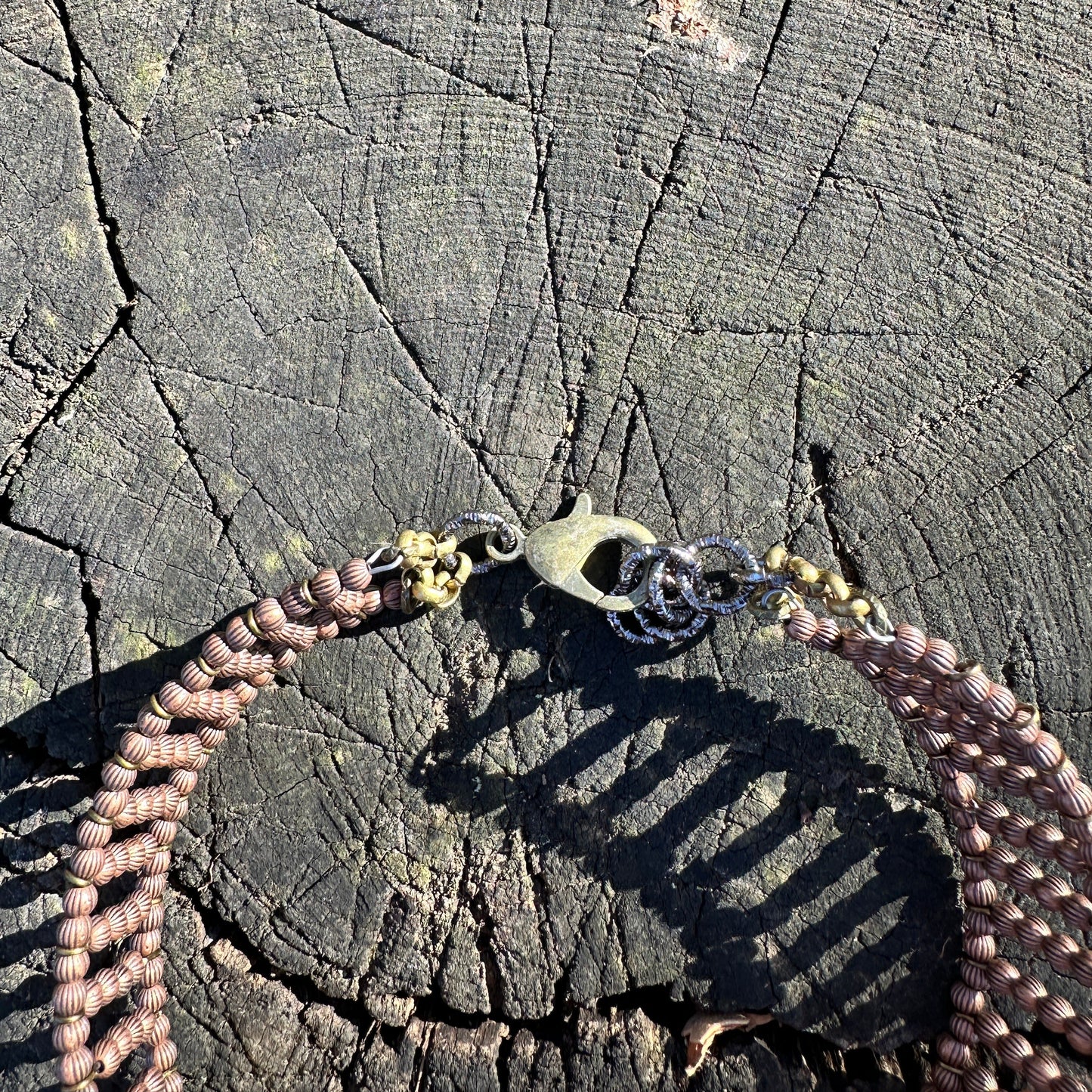 Braided necklace clasp on wood