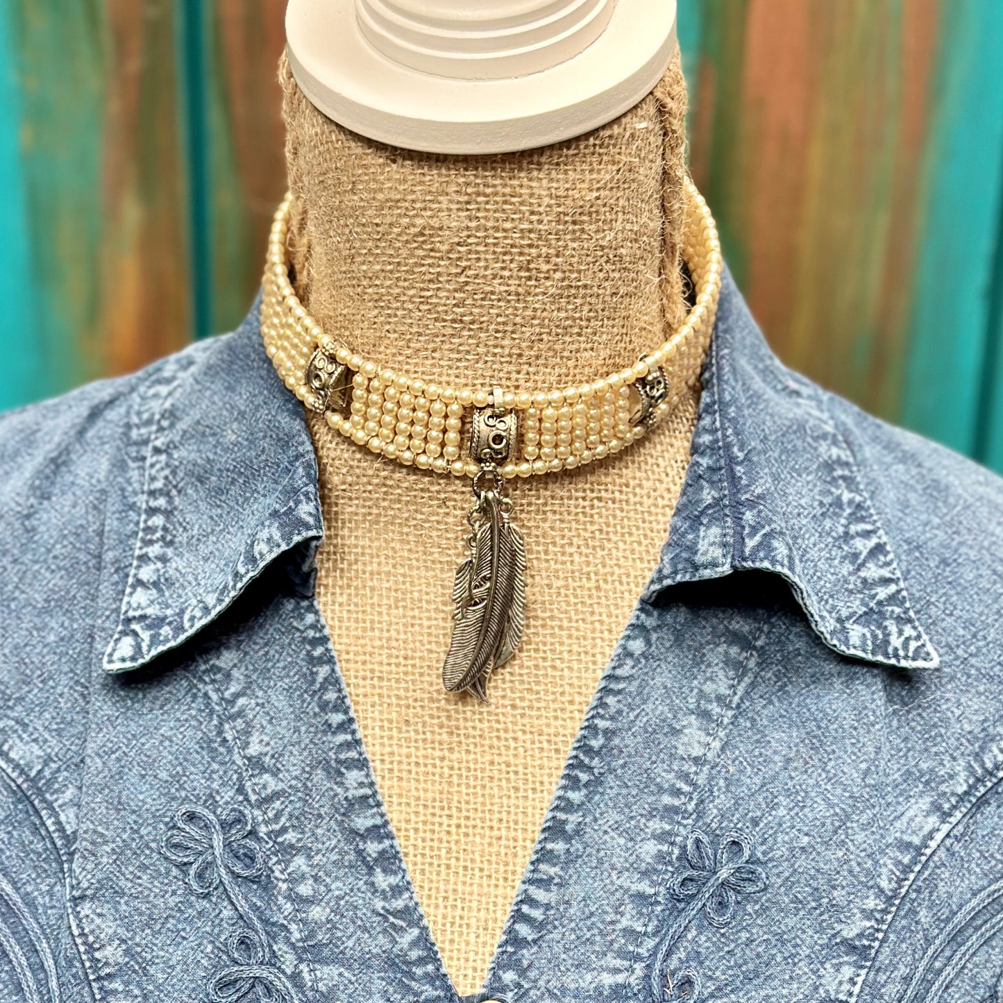 Beaded choker necklace with feather pendant.
