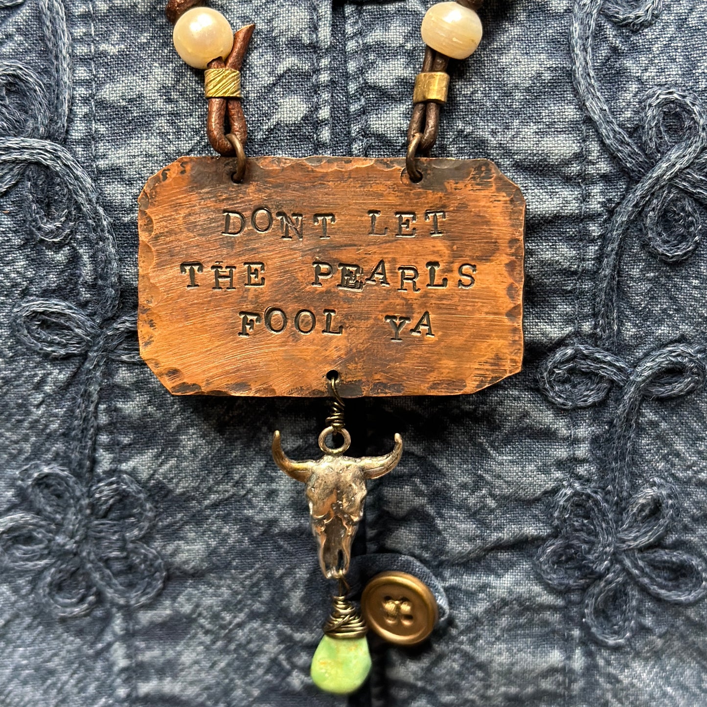 Copper necklace with text and bull skull pendant.